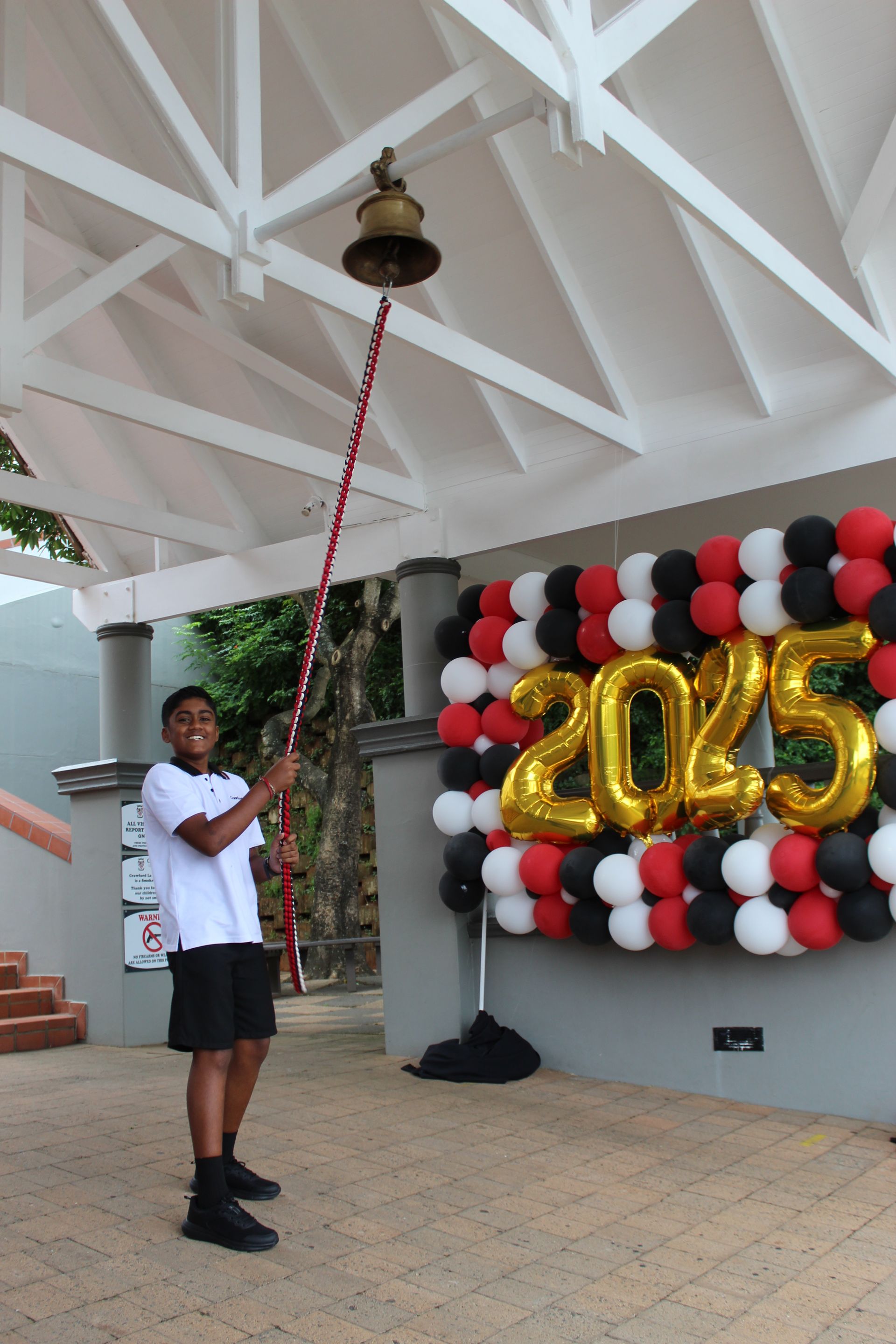 Teen ringing a bell with a long pole, by 