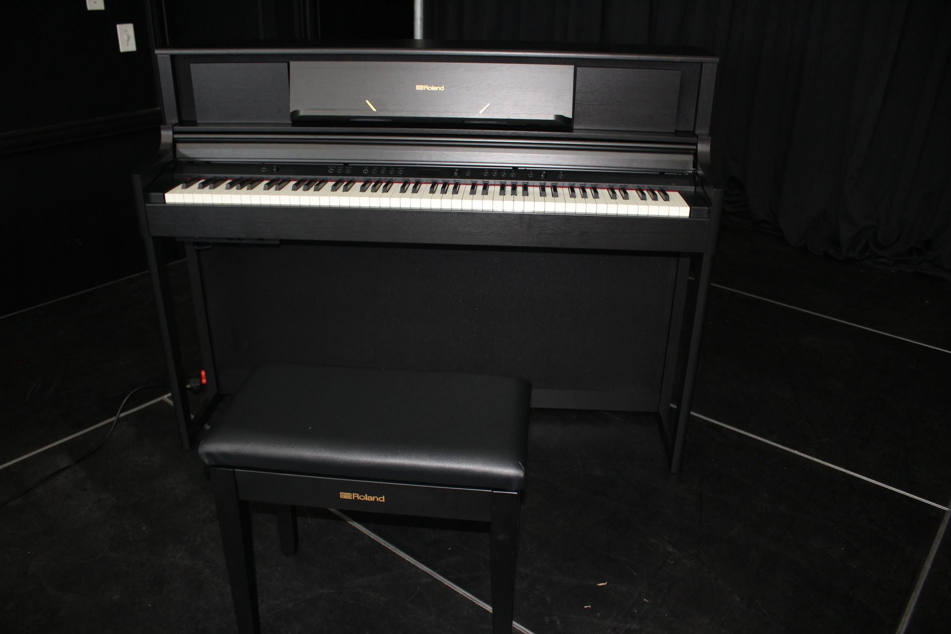 a black piano with a stool next to it