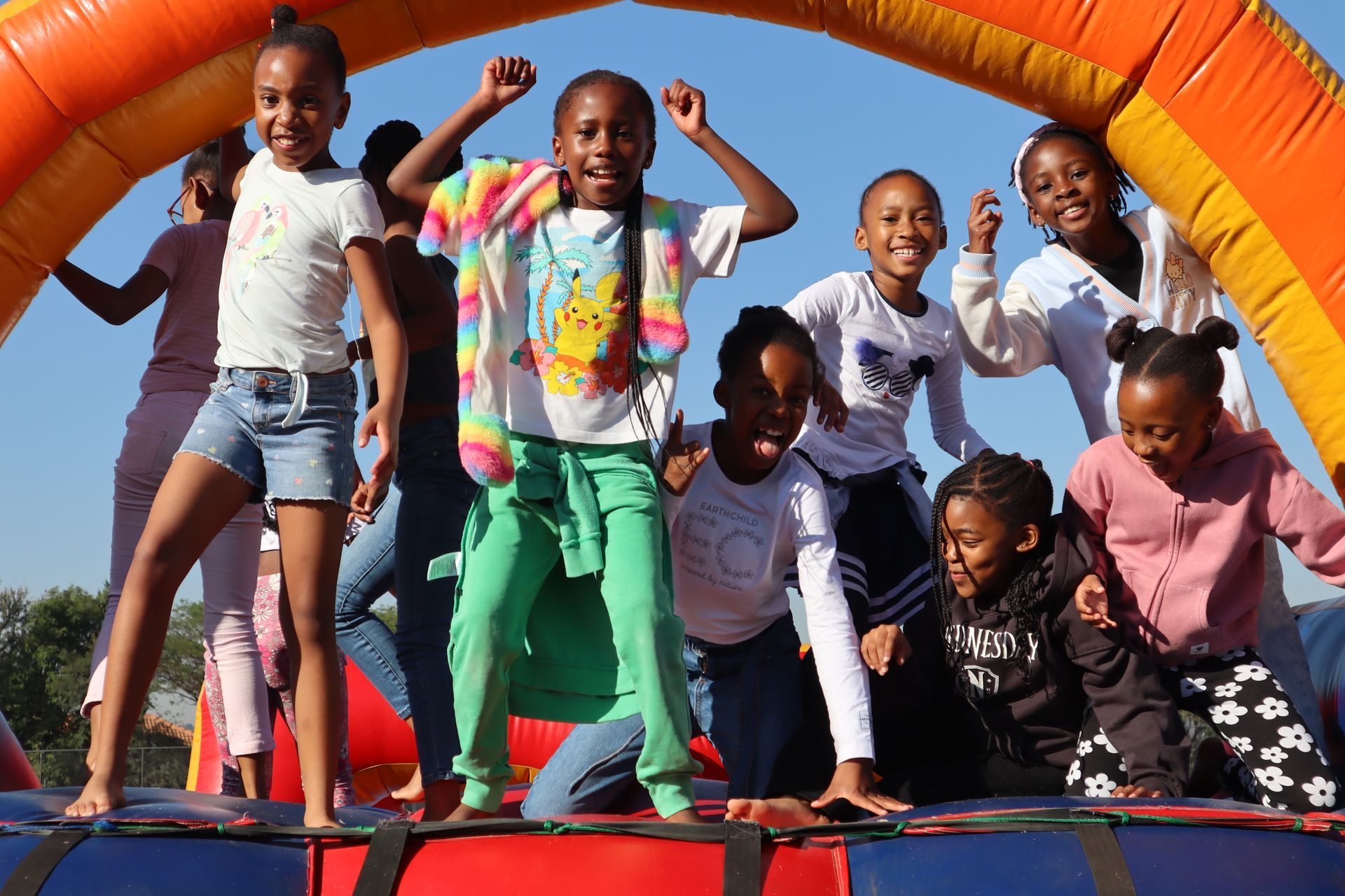 A group of young girls are playing on a bouncy house.