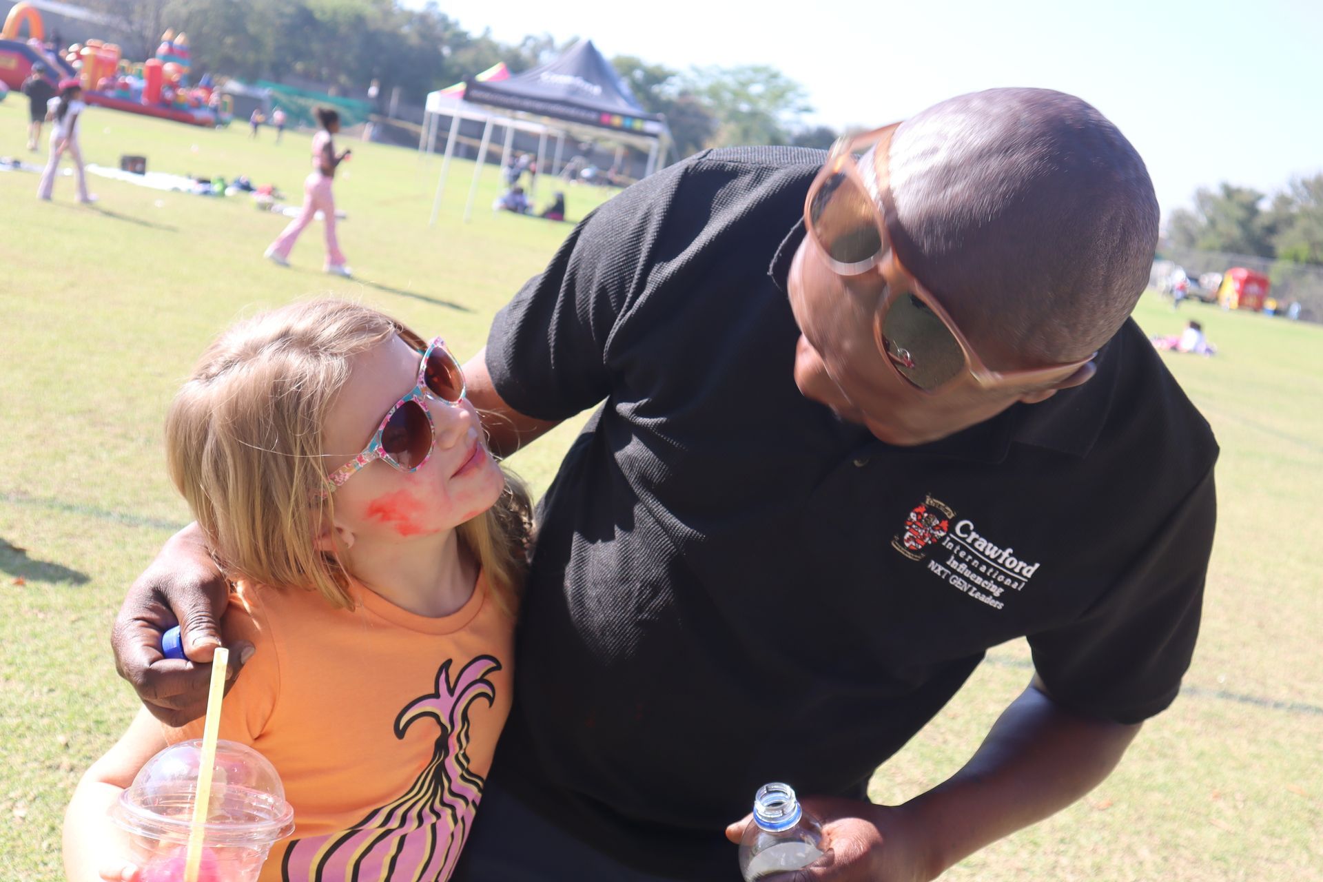 A man is holding a bottle of water next to a little girl.