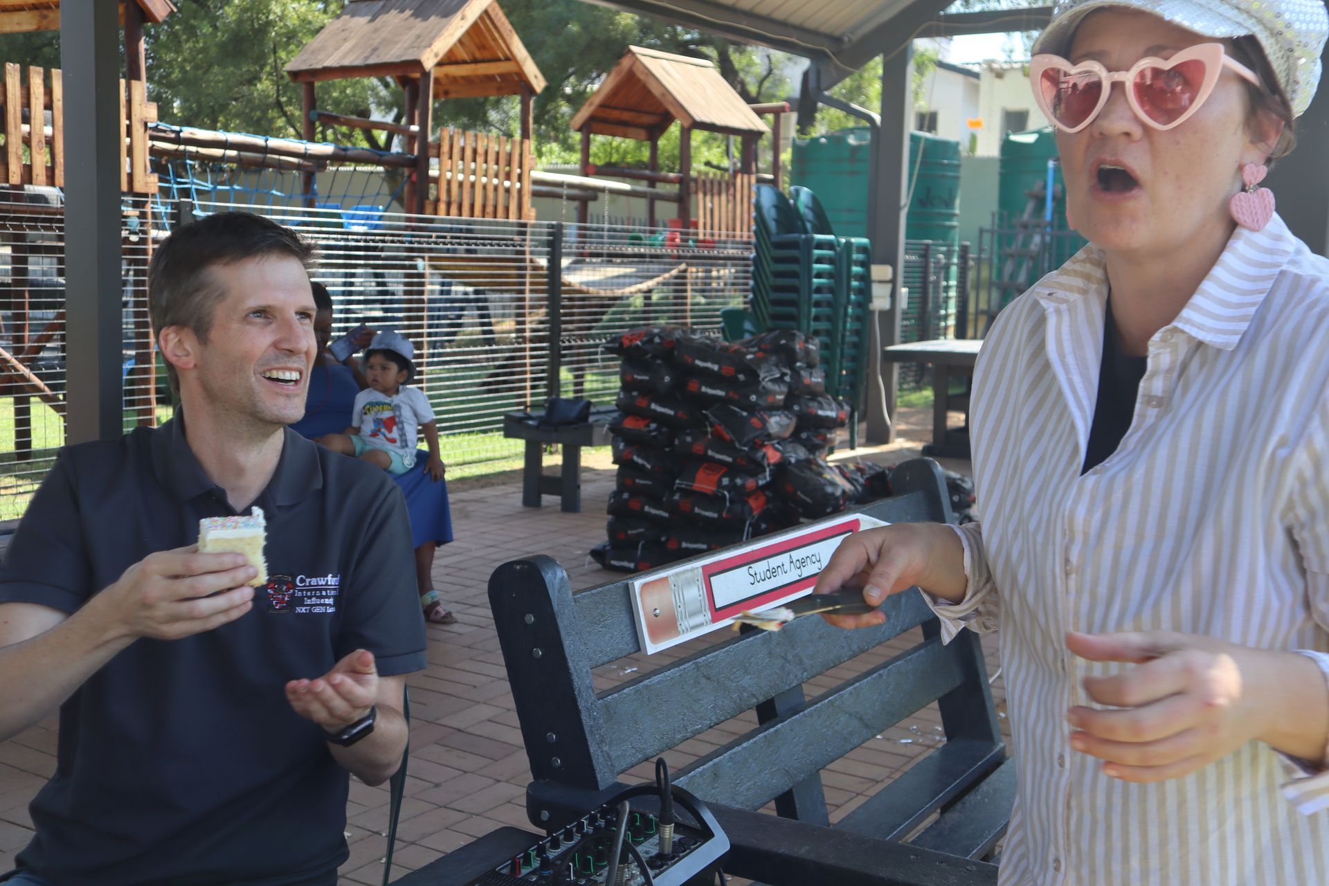 A man and a woman are sitting on a bench in a park.