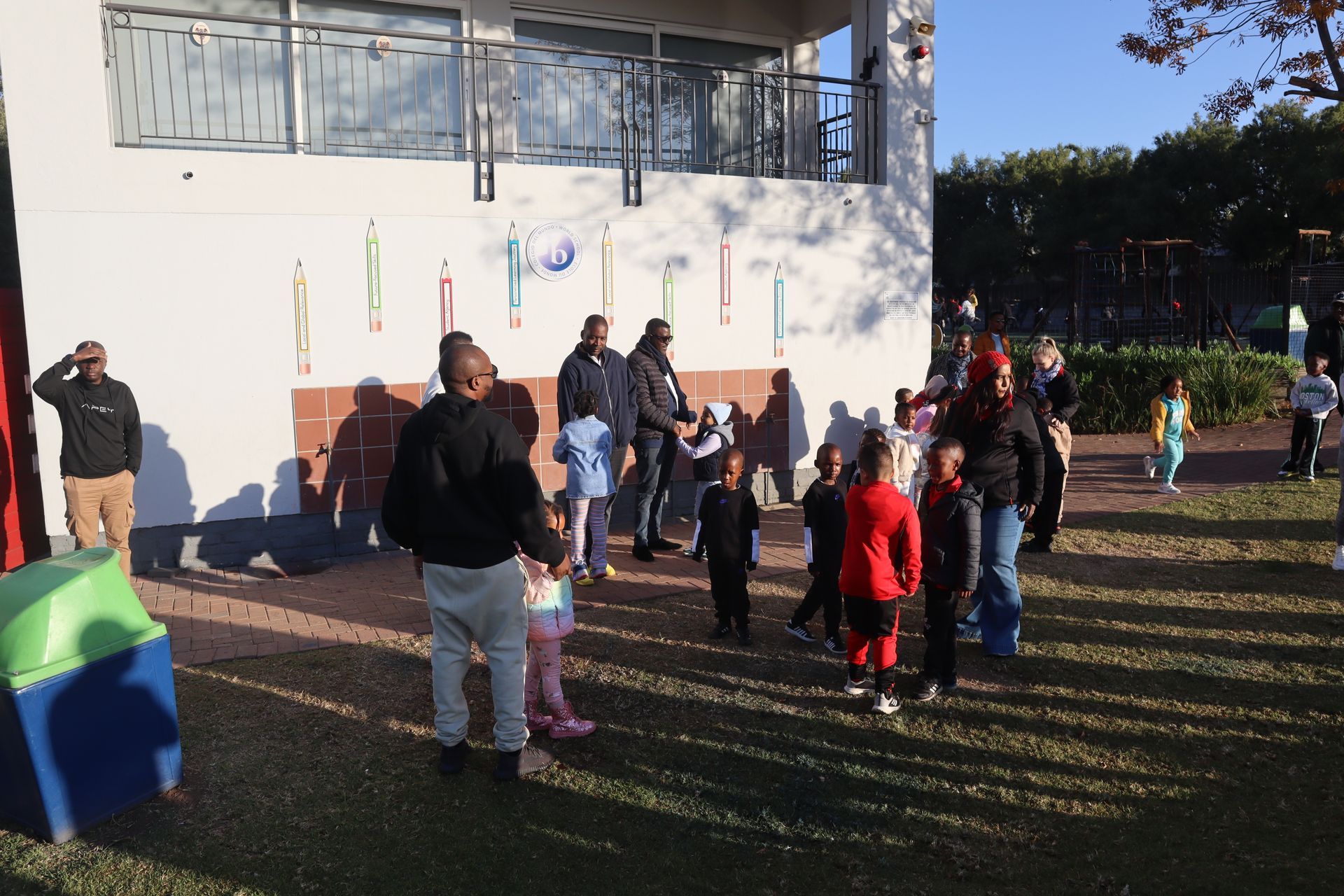 A group of people are standing in front of a white building