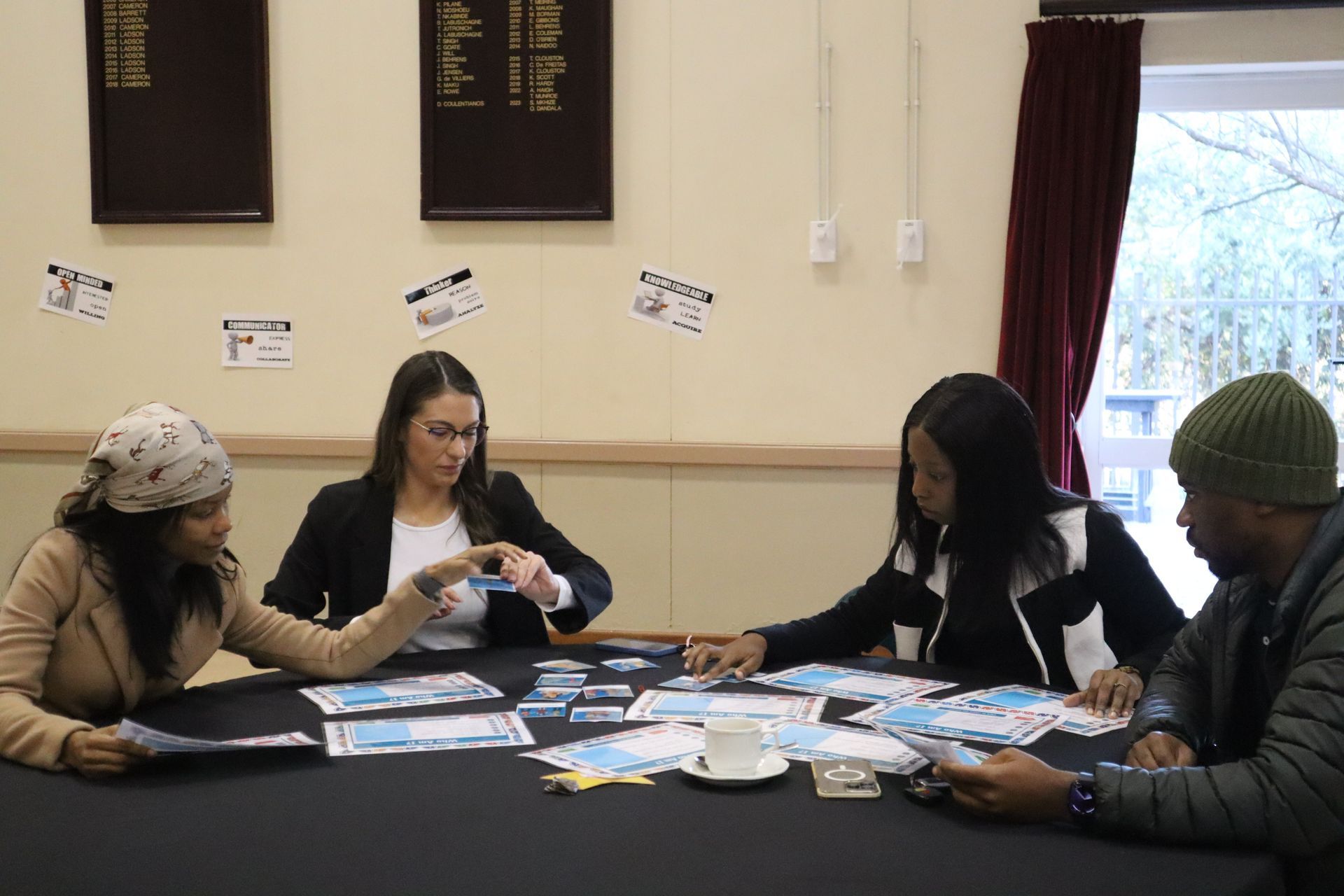 A group of people are sitting around a table playing a game.