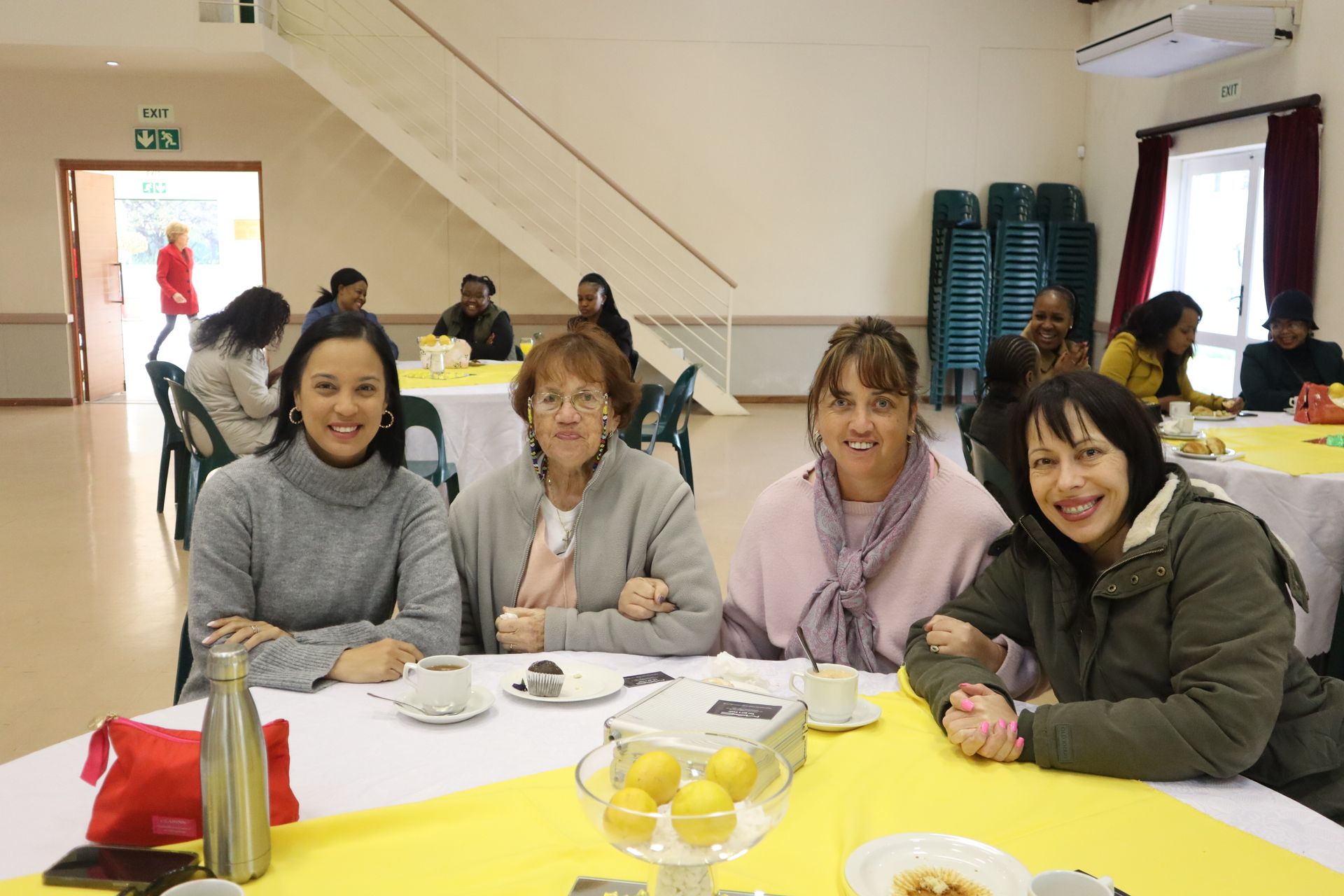 A group of women are sitting at a table in a room.