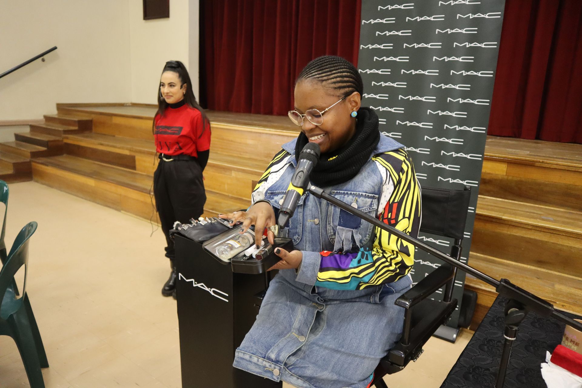 A woman in a wheelchair is playing a dj set in front of a microphone.