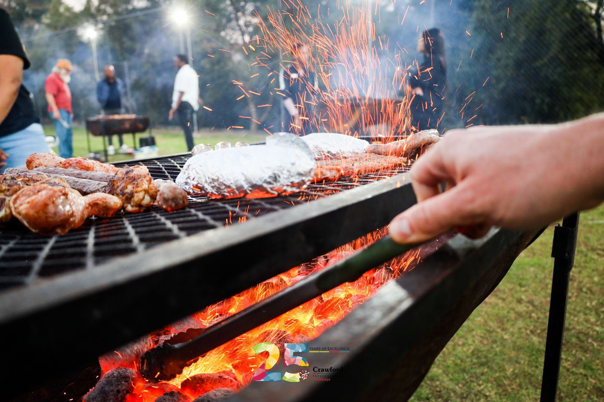 A person is cooking food on a grill in a park.