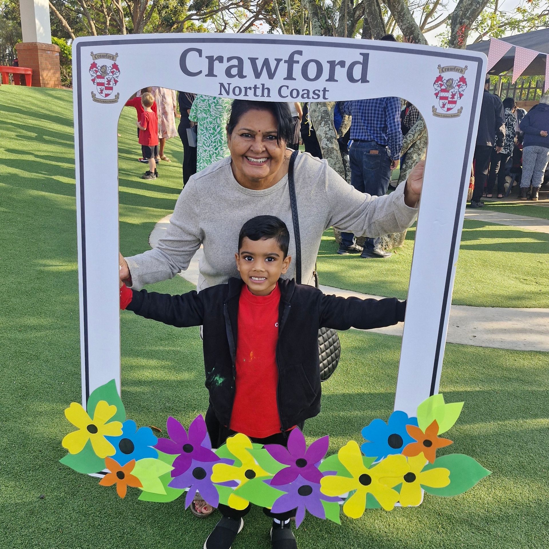 A woman and child are posing for a picture in front of a sign that says crawford north coast
