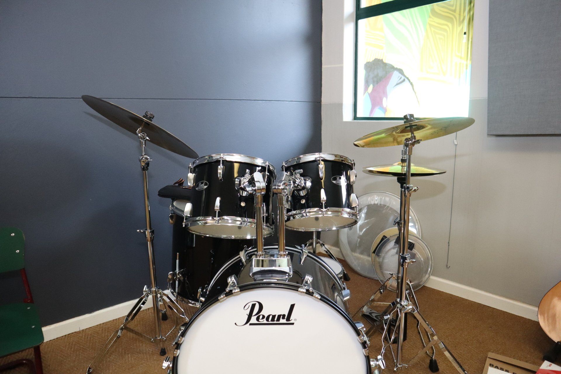 a pearl drum set in a room with a window