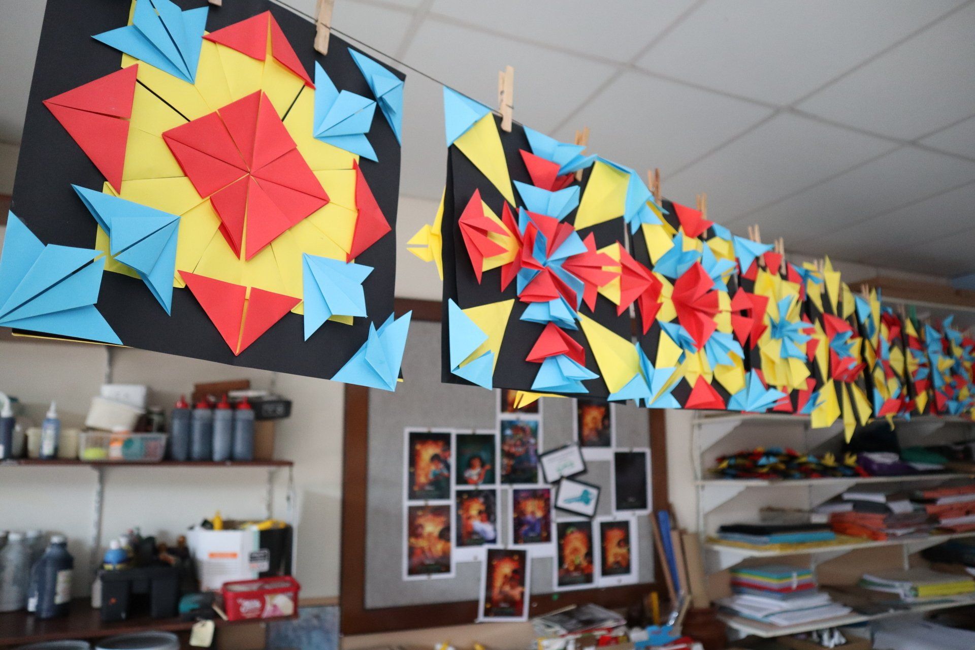 a row of colorful origami pieces hanging from the ceiling