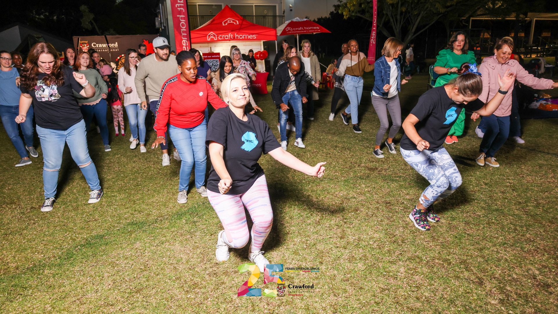A group of people are dancing in a field at night.