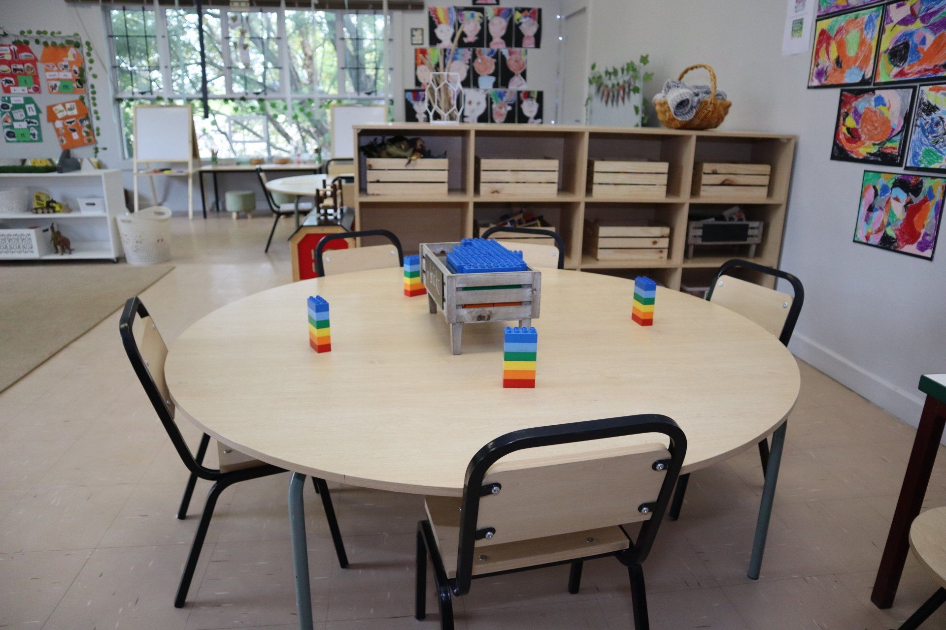 a classroom with a round table and chairs .