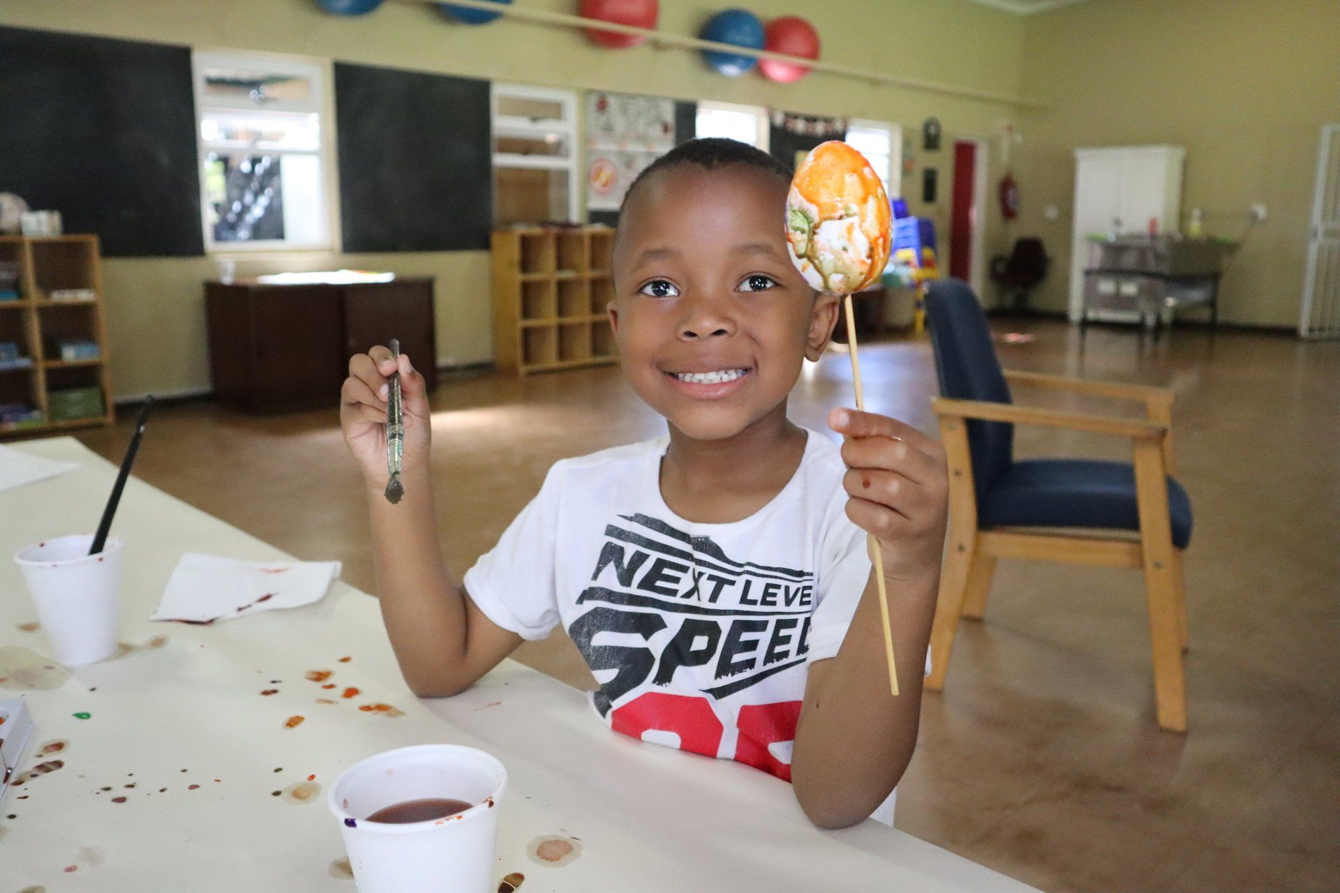 a young boy wearing a shirt that says next level speed is holding a lollipop
