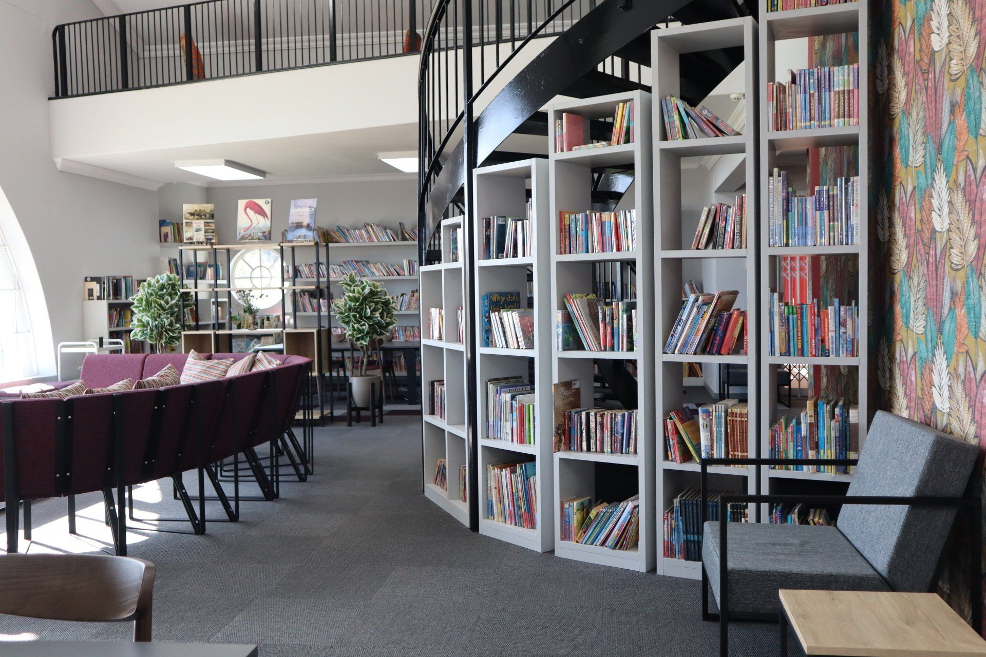 a library with lots of bookshelves and chairs