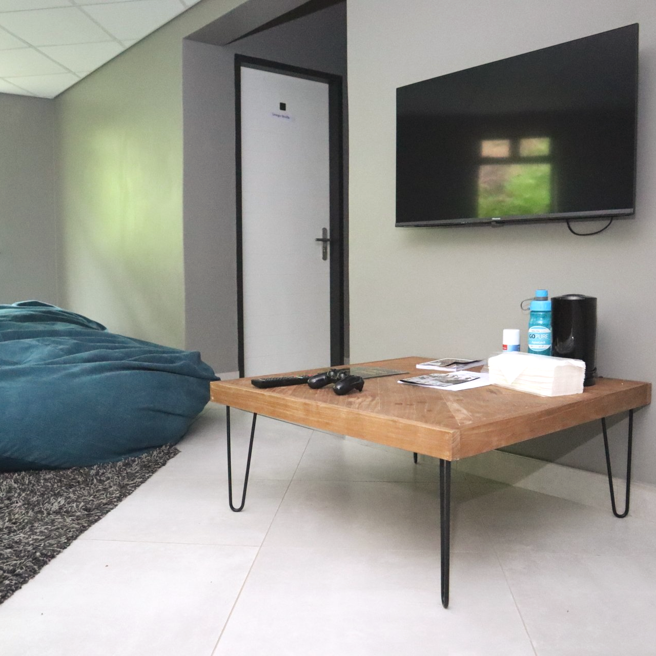 A living room with a bean bag chair and a flat screen tv