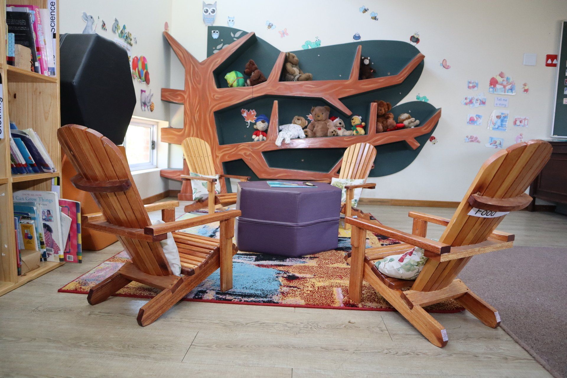 a room with wooden chairs and a purple ottoman