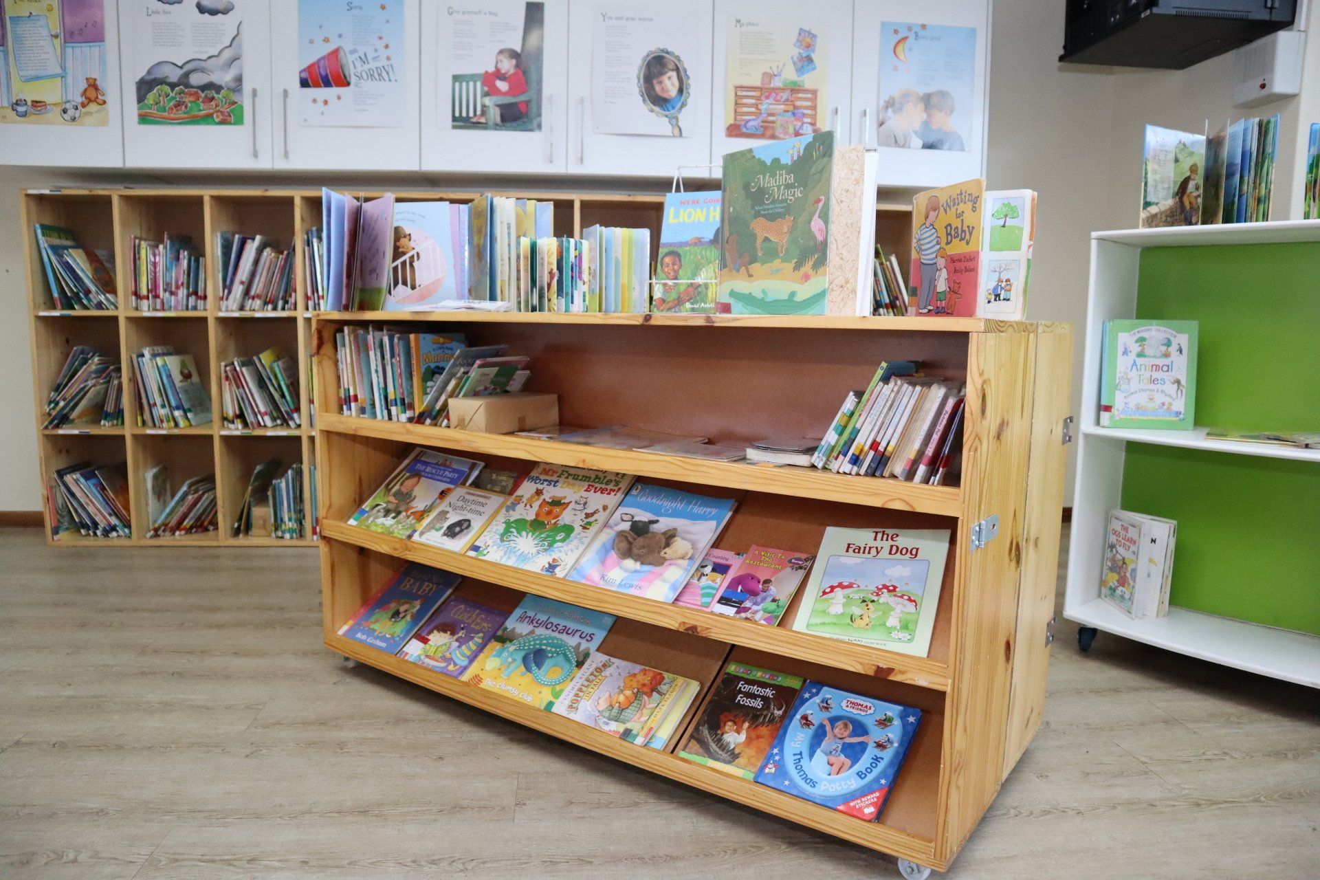 a wooden shelf filled with books in a library .