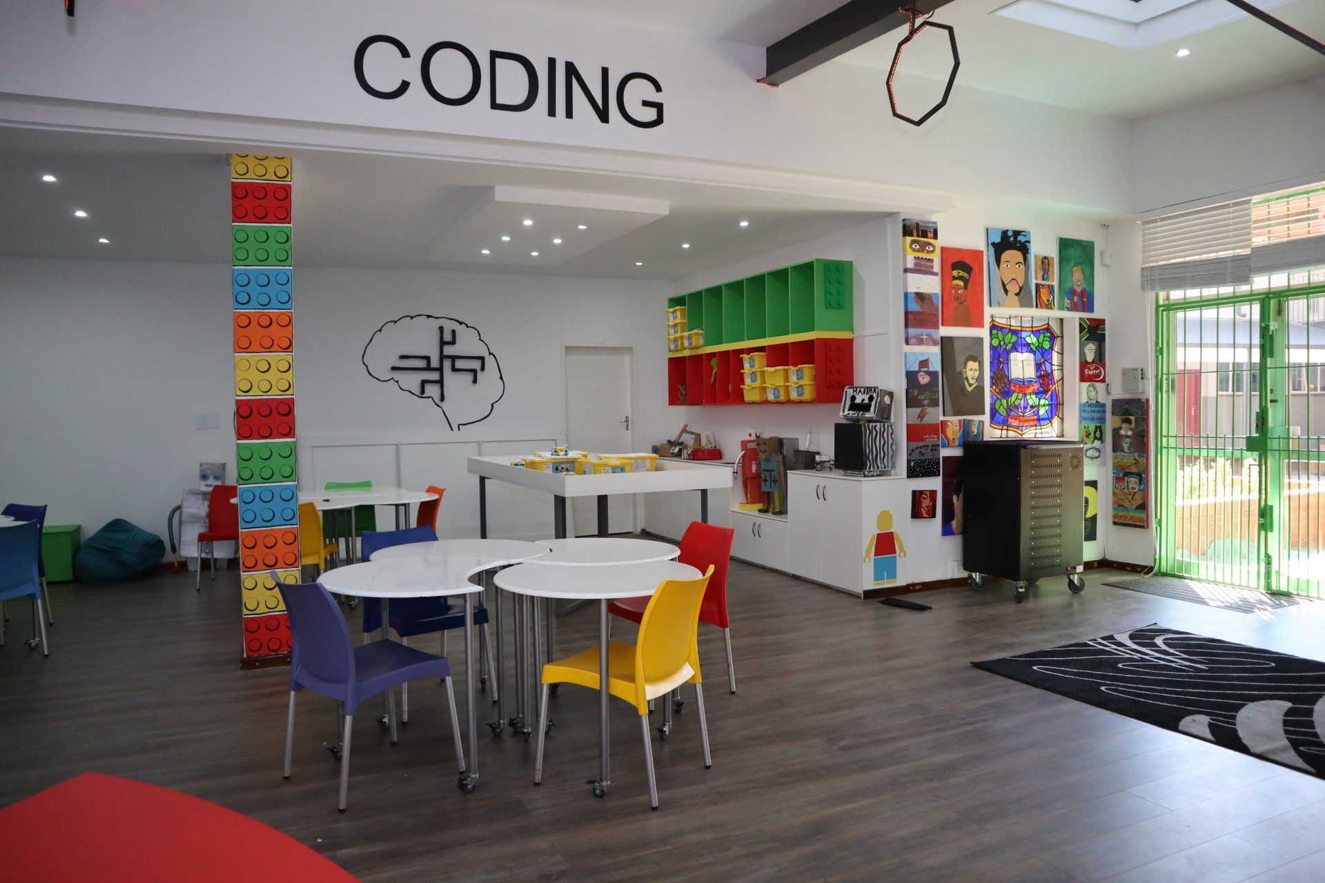 a room with tables and chairs and the word coding on the wall