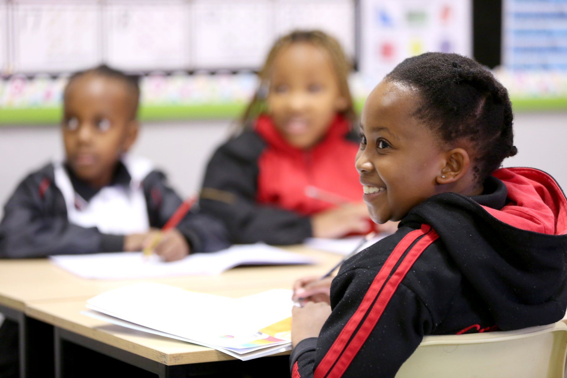 A group of children are sitting at desks in a classroom.
