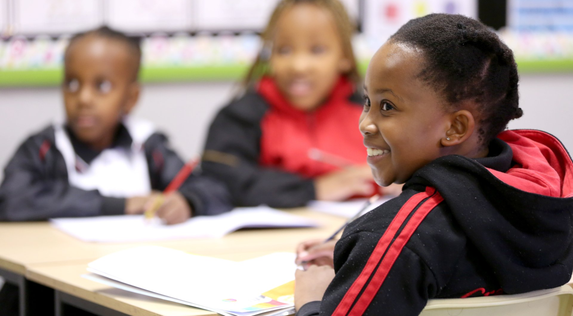 a group of children are sitting at desks in a classroom .