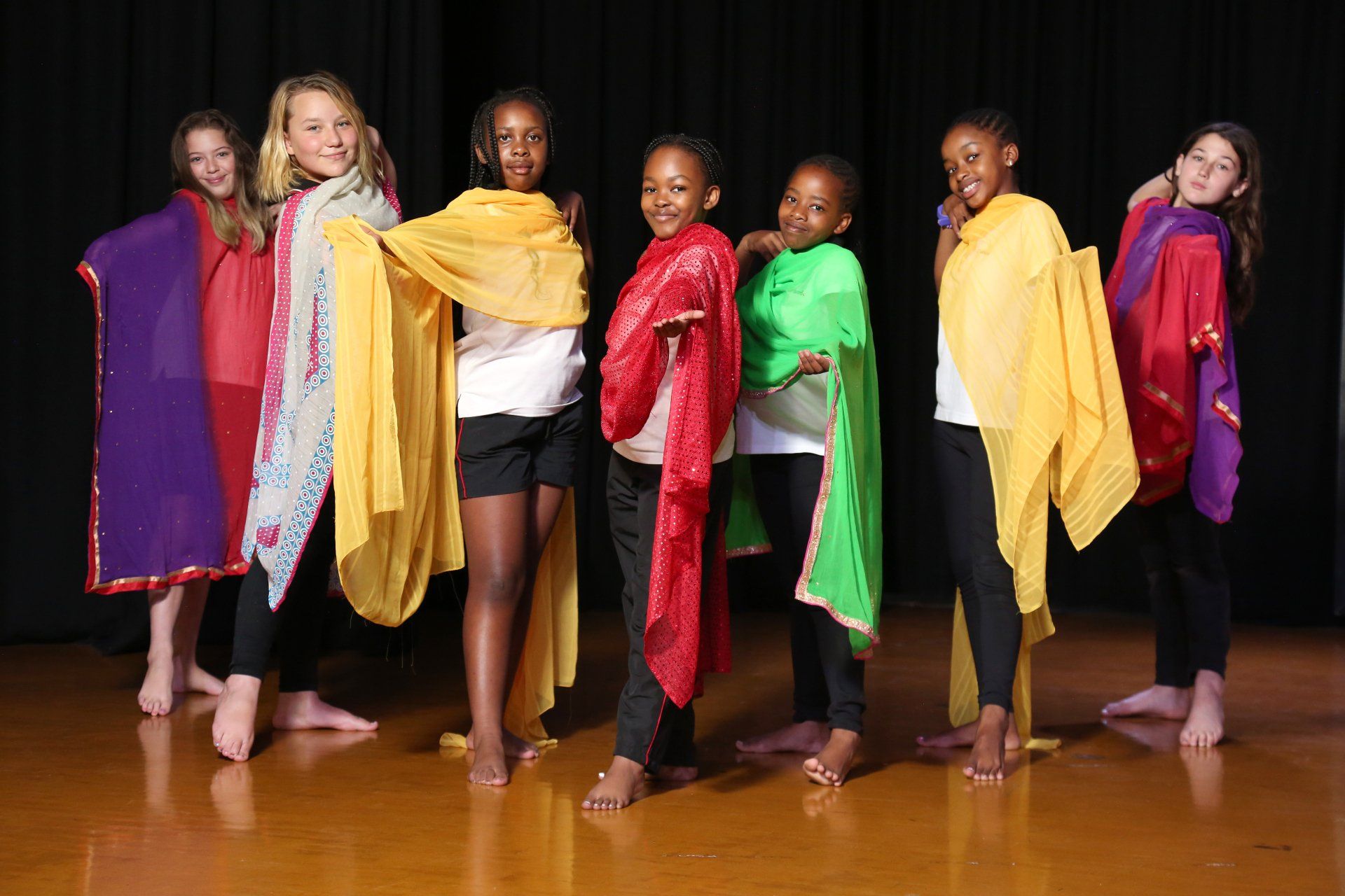 a group of young girls are posing for a picture on a stage .