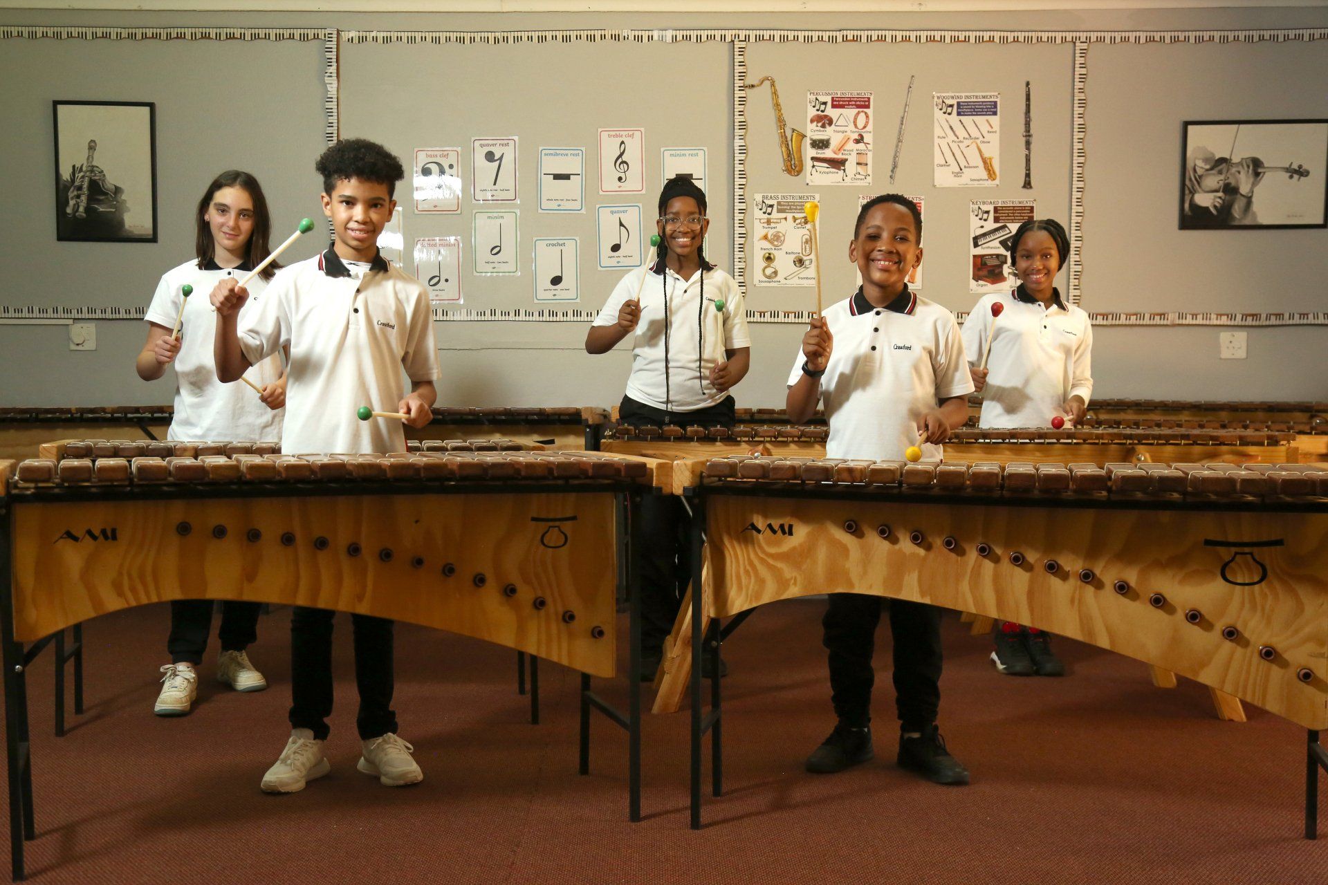 a group of children are playing xylophones in a classroom .