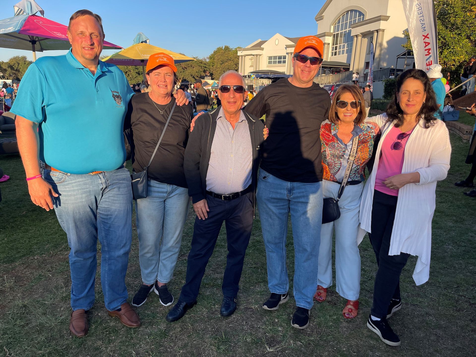 A group of people are posing for a picture in a park.