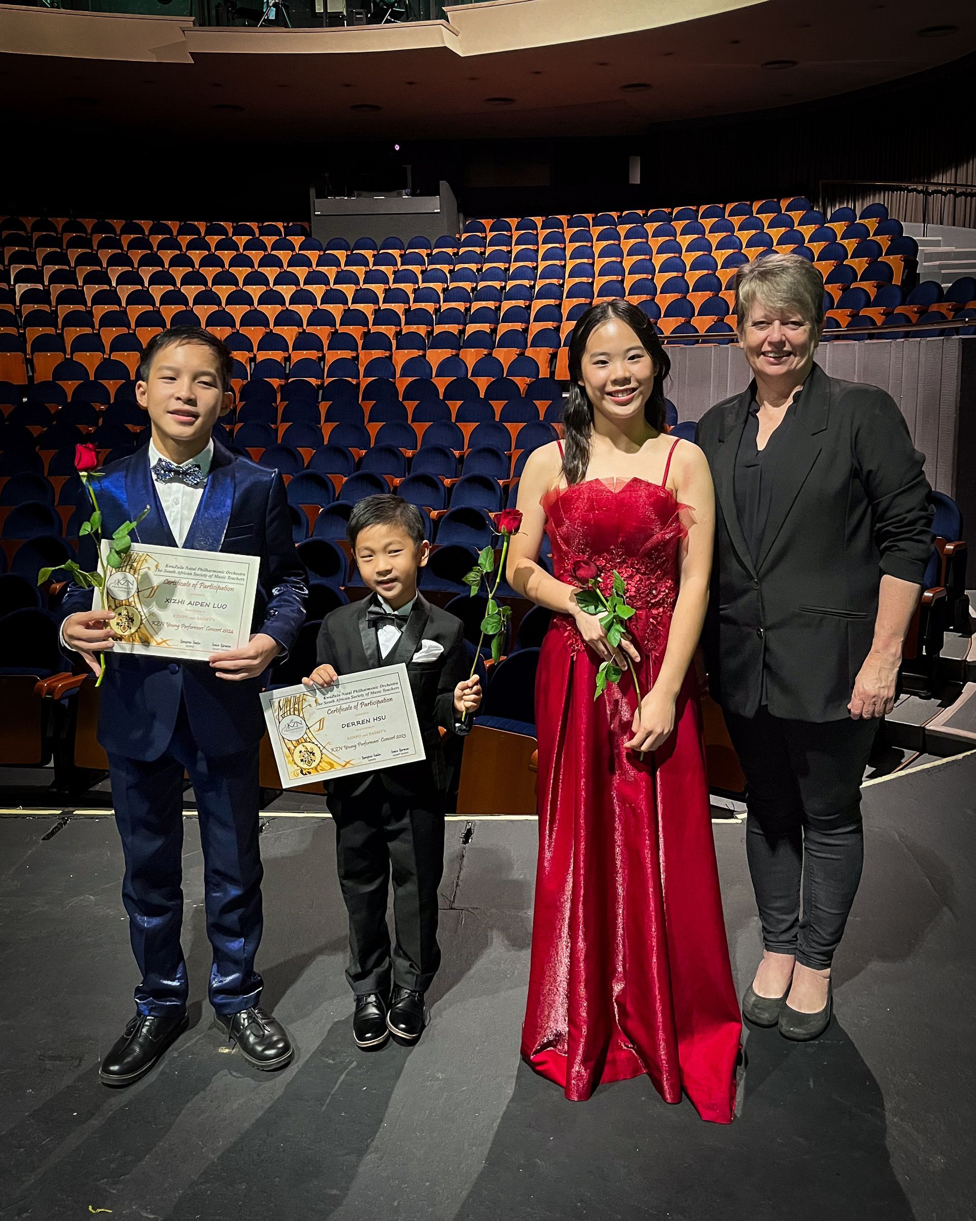 A group of people are posing for a picture in an auditorium.