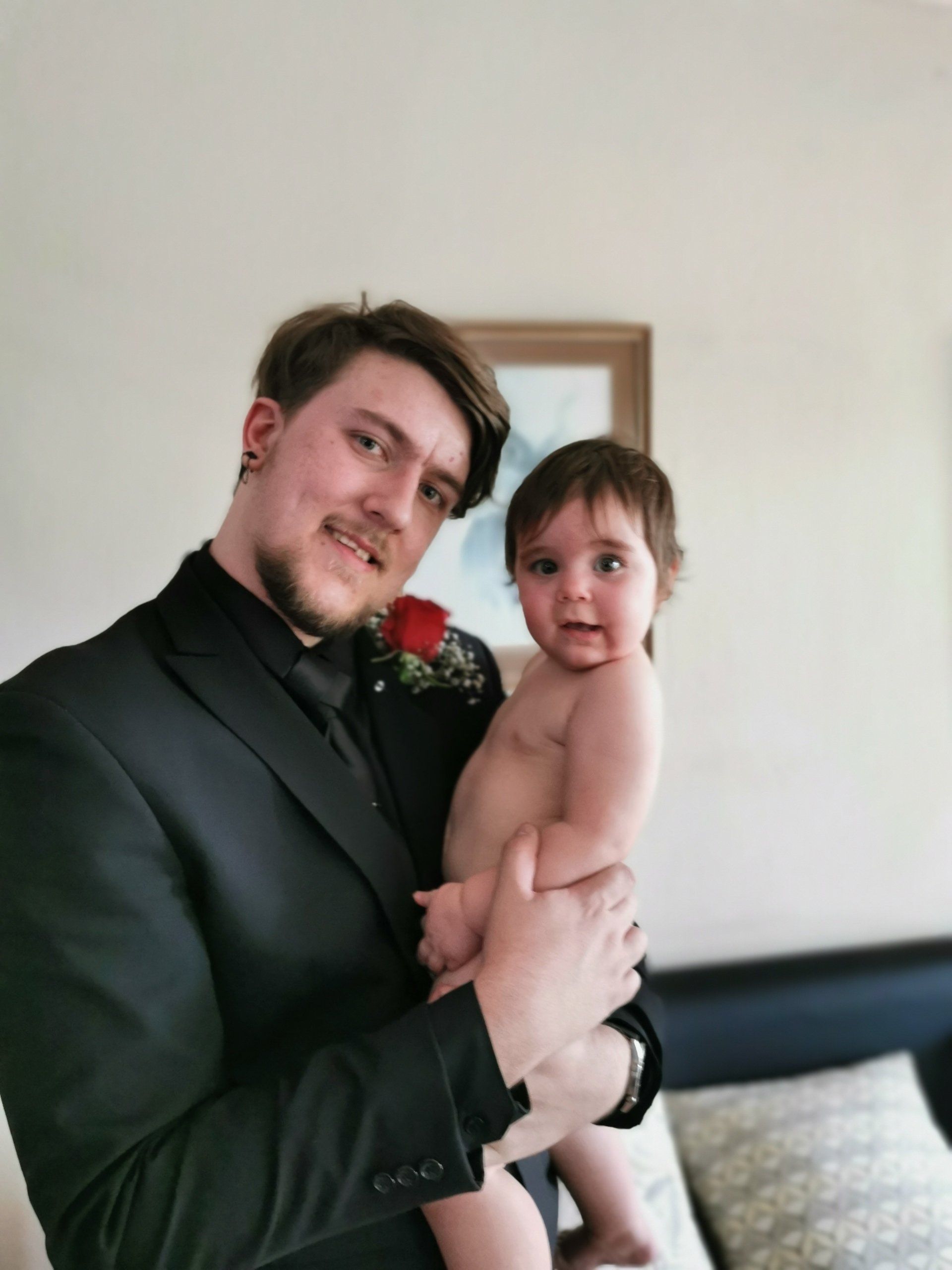 A man in a suit is holding a baby in his arms