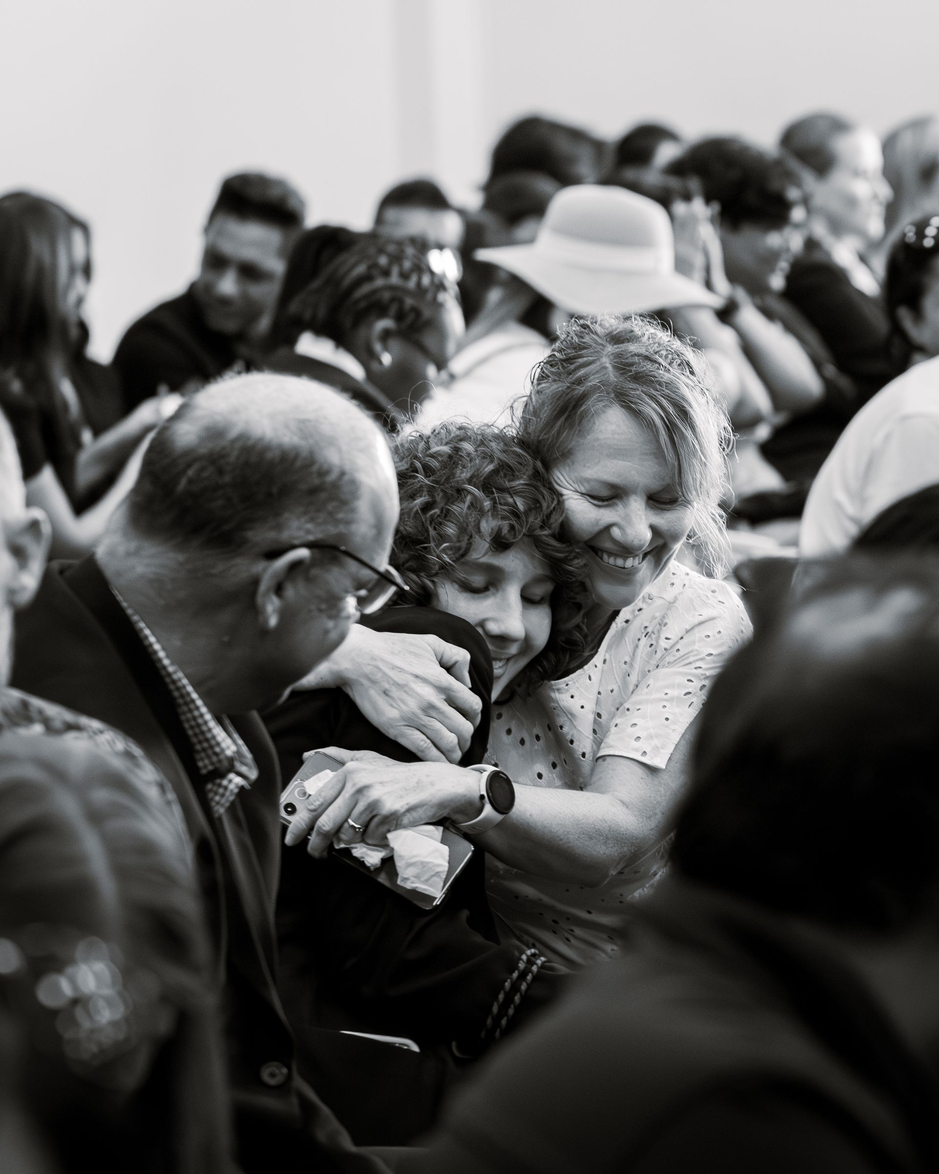 A black and white photo of a group of people hugging each other