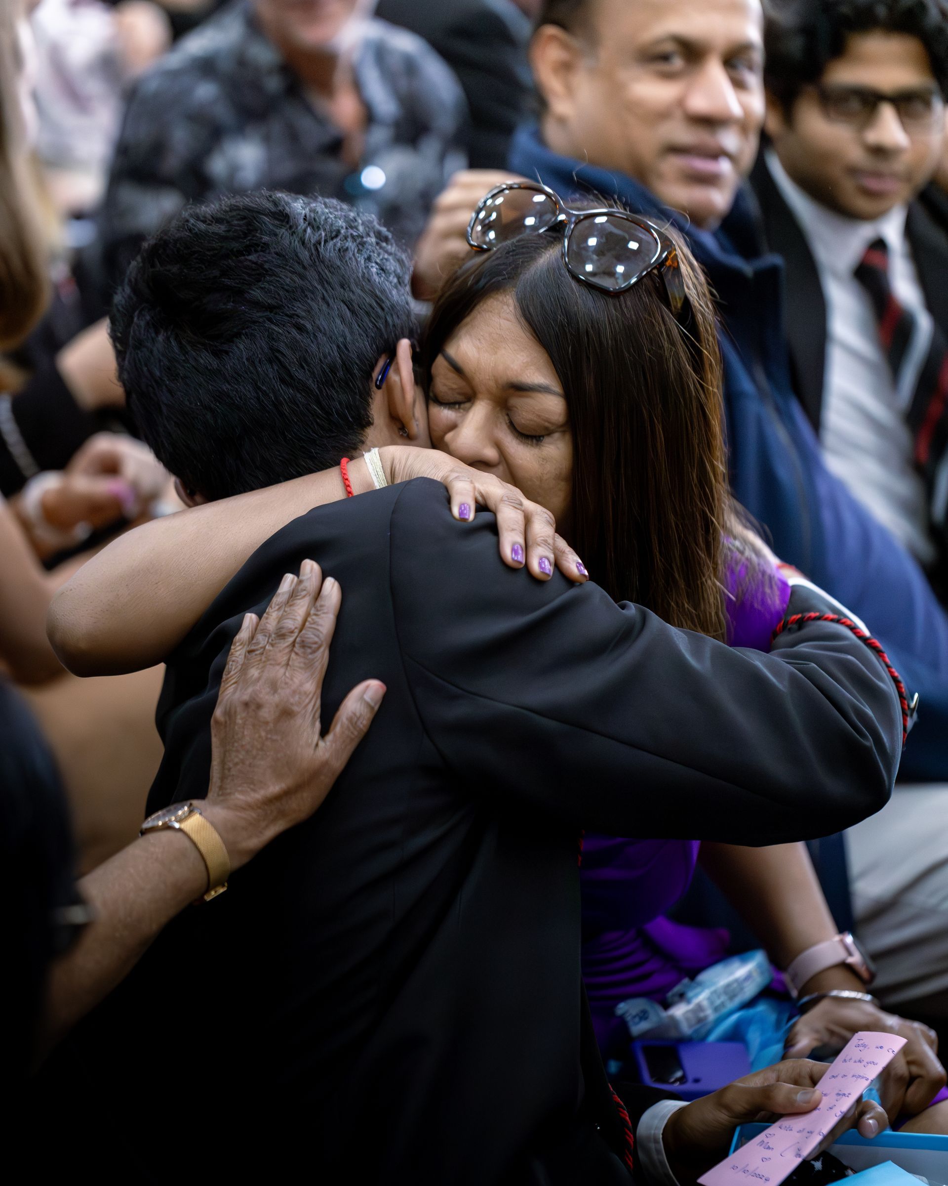 A woman is hugging a man in a crowd of people
