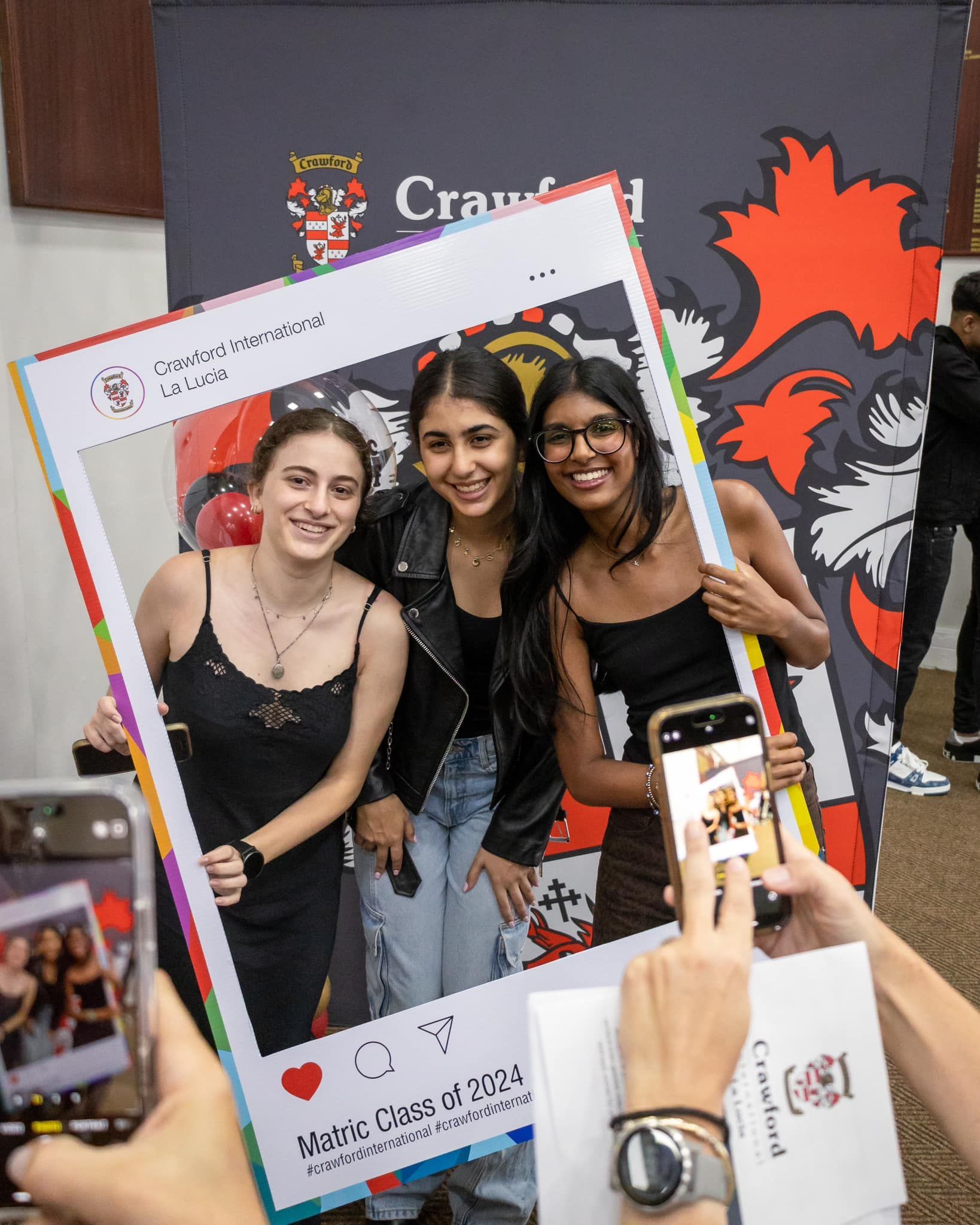 Three smiling people pose in a social media frame in front of a Cranfield University backdrop.