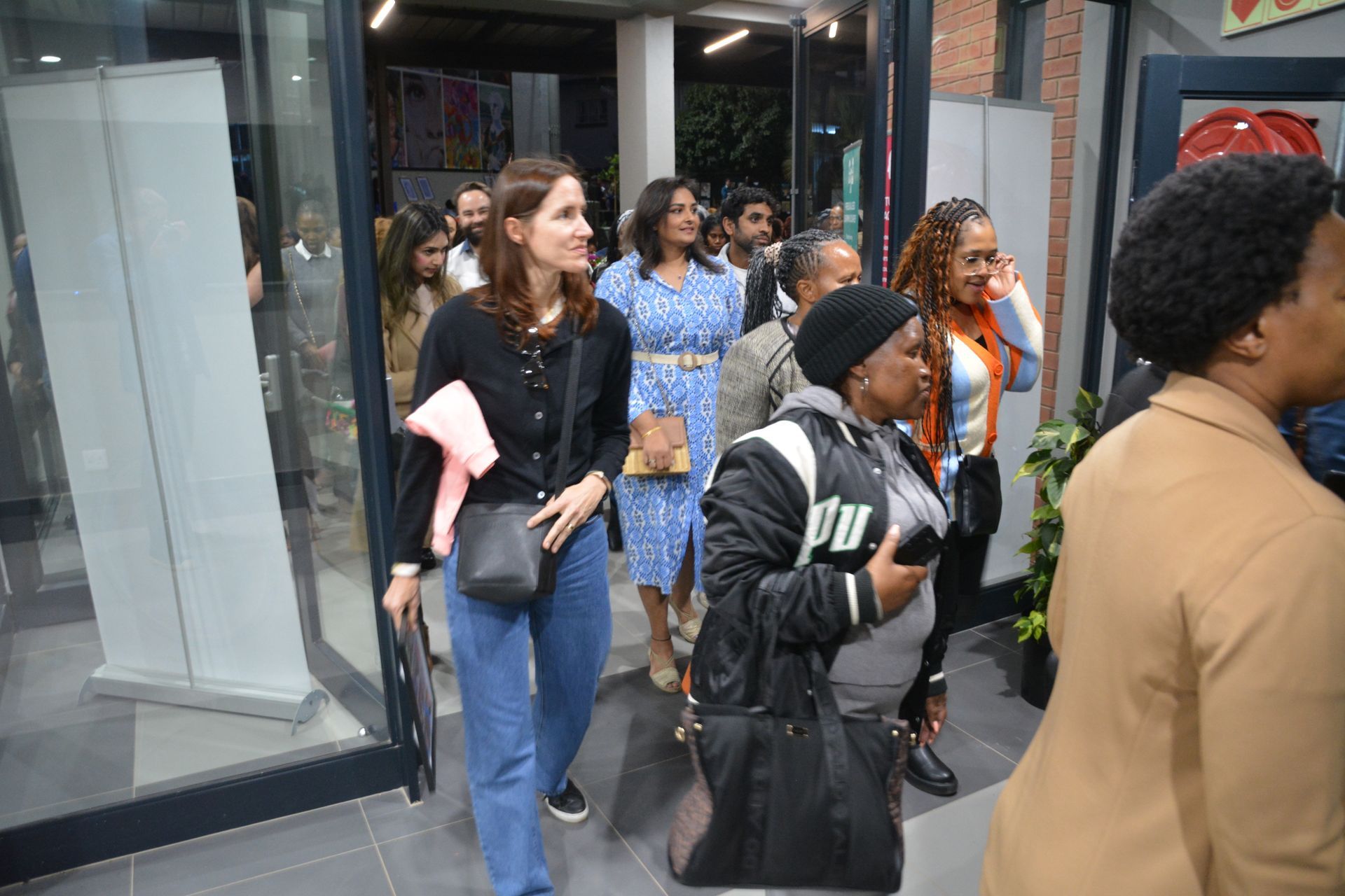 A group of people are walking down a sidewalk.