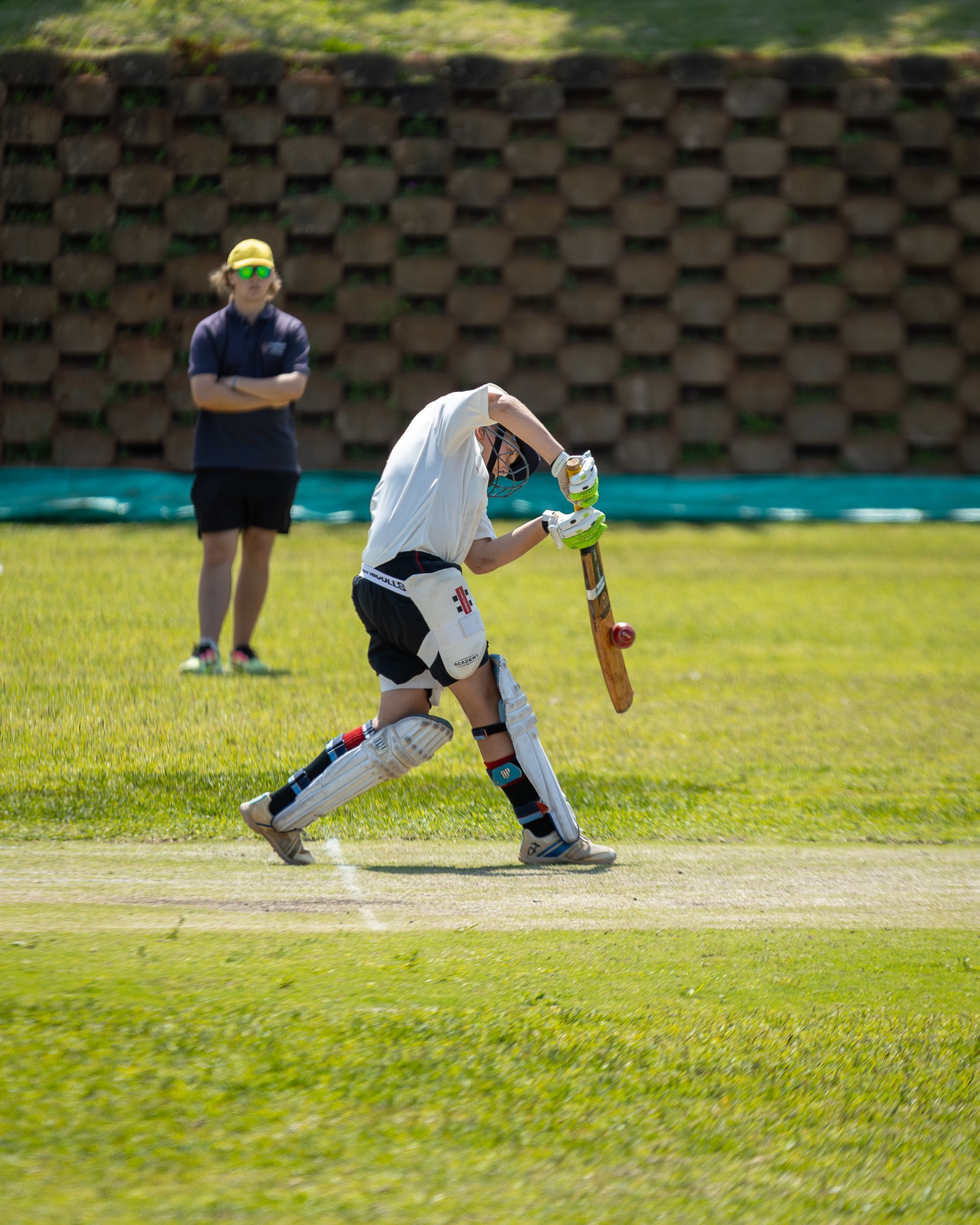 A man is playing a game of cricket on a field.