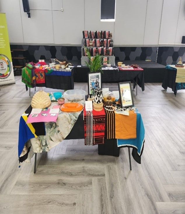 Tables displaying various crafts and products at an event, with colorful textiles and items on display.
