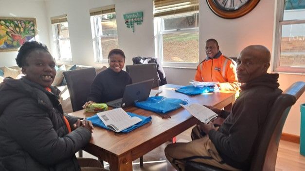 A group of people are sitting at a table with laptops.
