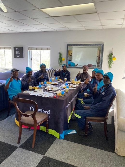 A group of people are sitting around a table eating food.