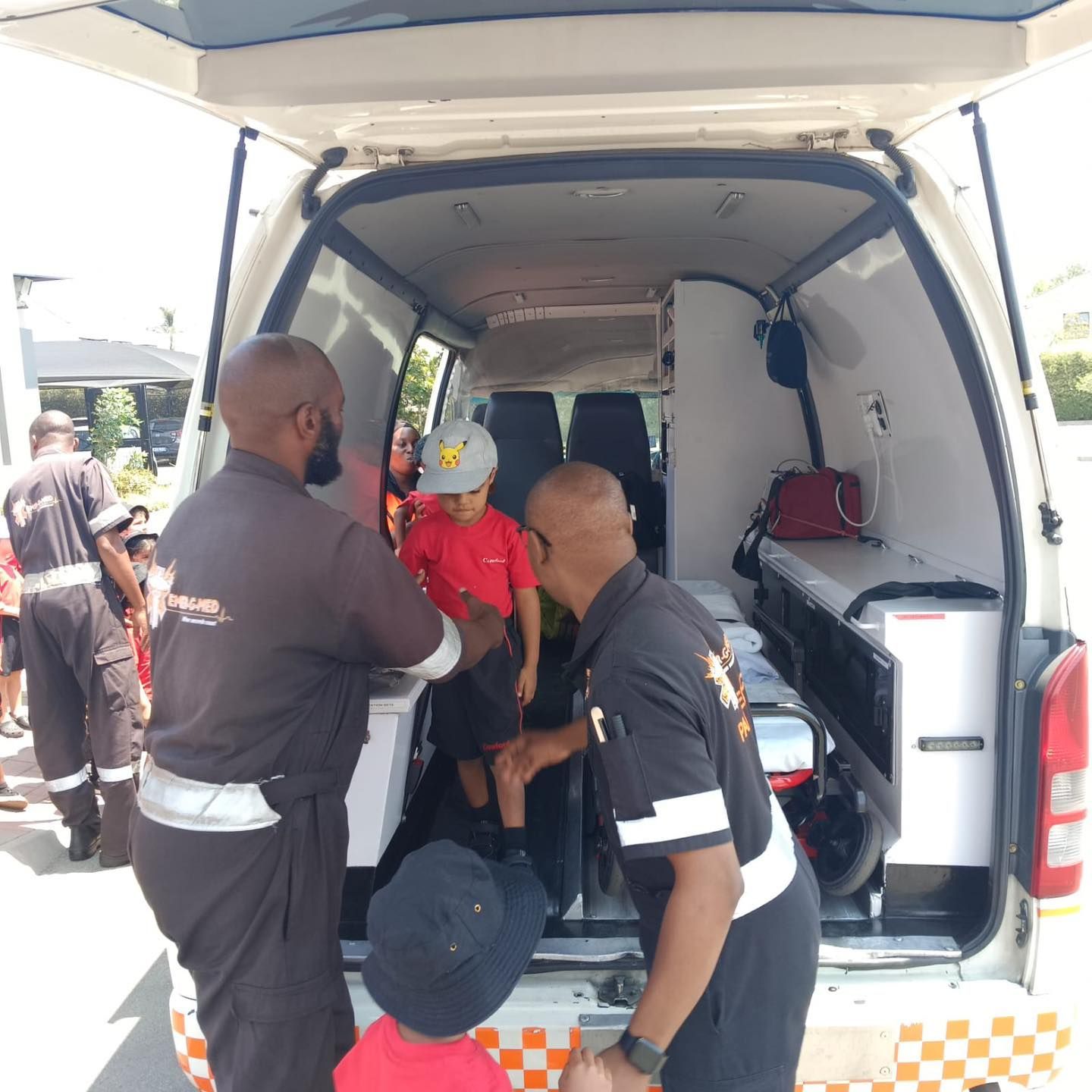 A group of people are standing in the back of an ambulance