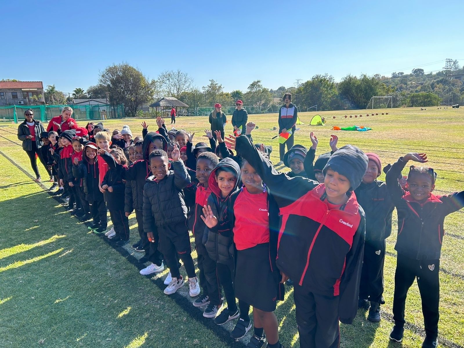 A group of children are standing in a line on a field.