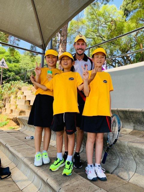 A group of children wearing yellow shirts are posing for a picture