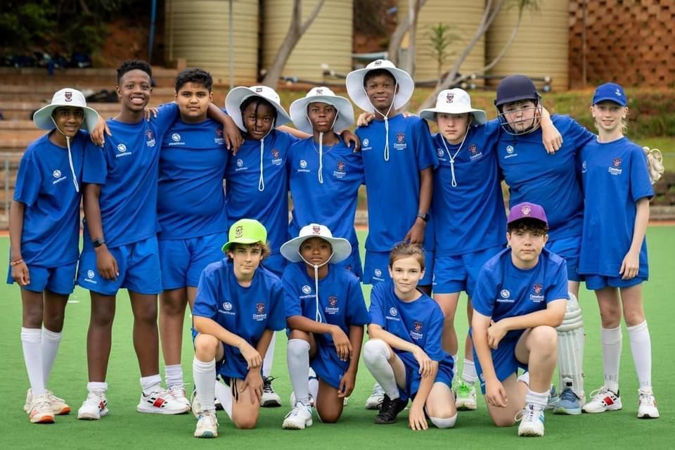 A group of young boys are posing for a picture on a field.