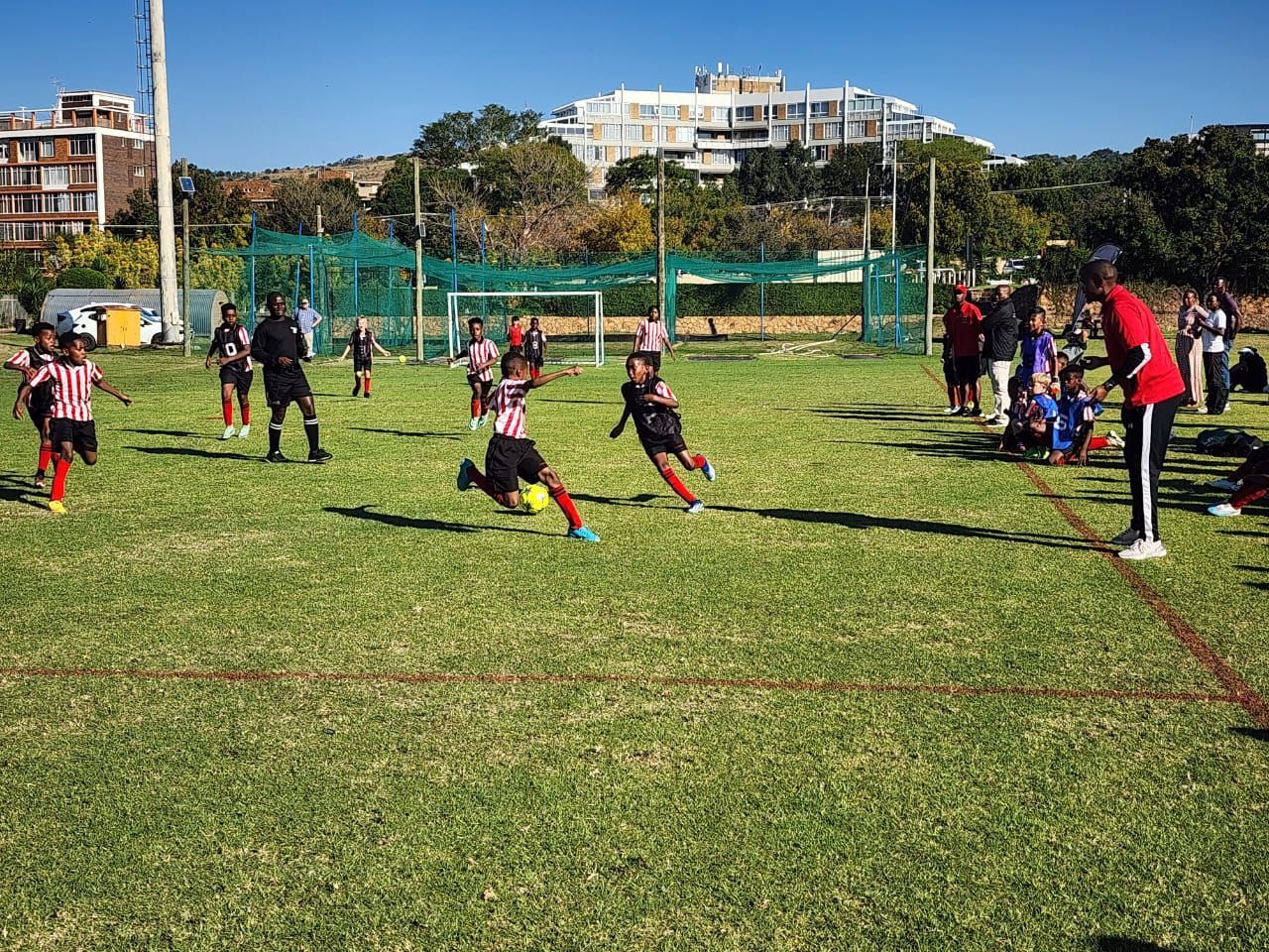 A group of children are playing soccer on a field.
