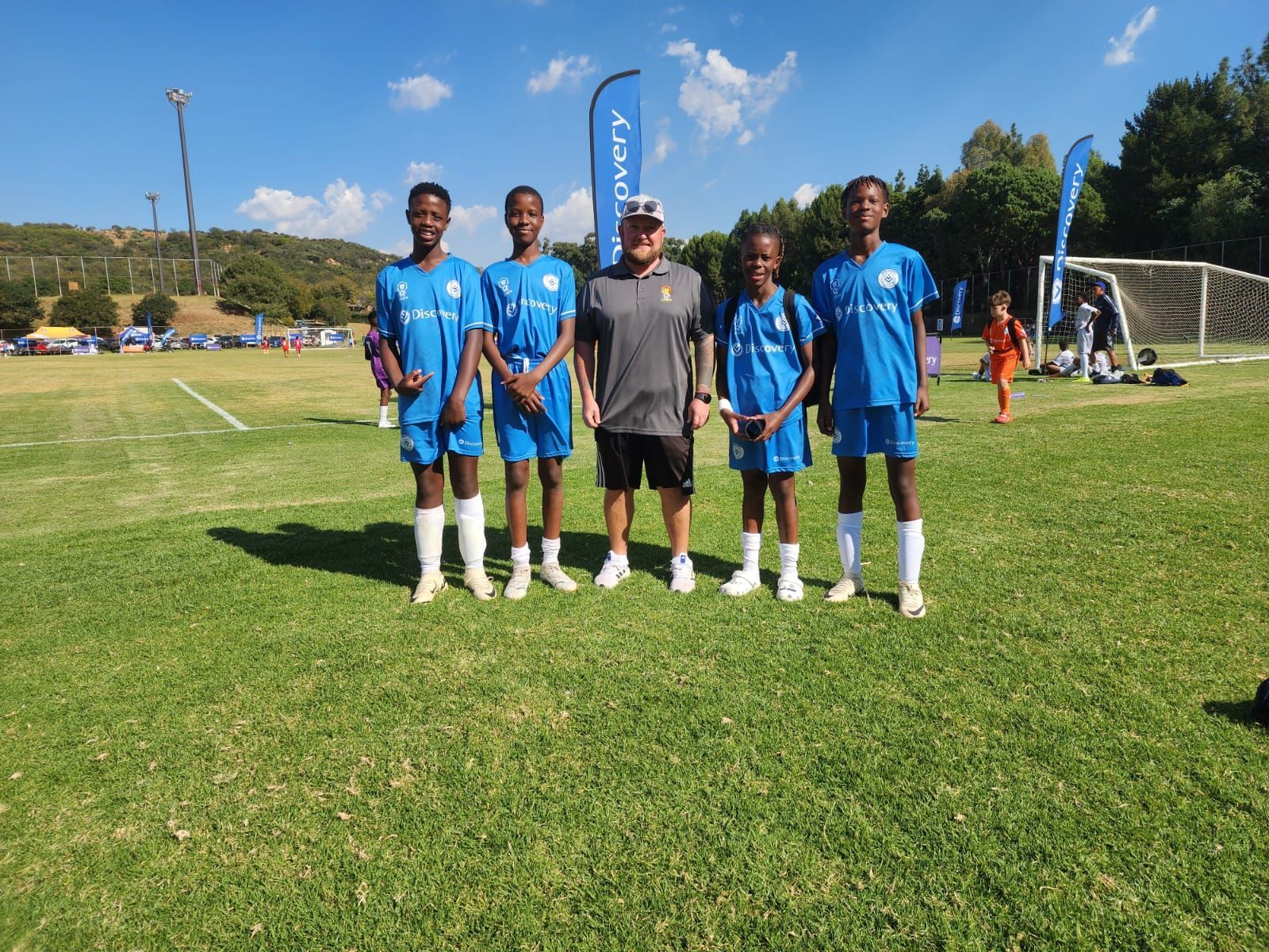 A group of soccer players are posing for a picture on a field.