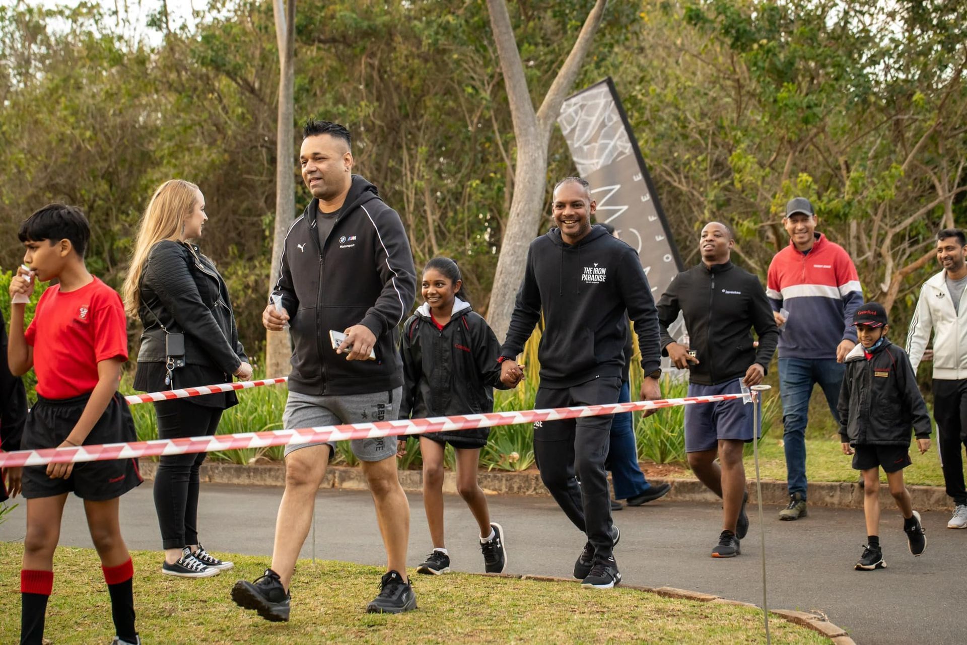 A group of people are walking down a street holding hands.