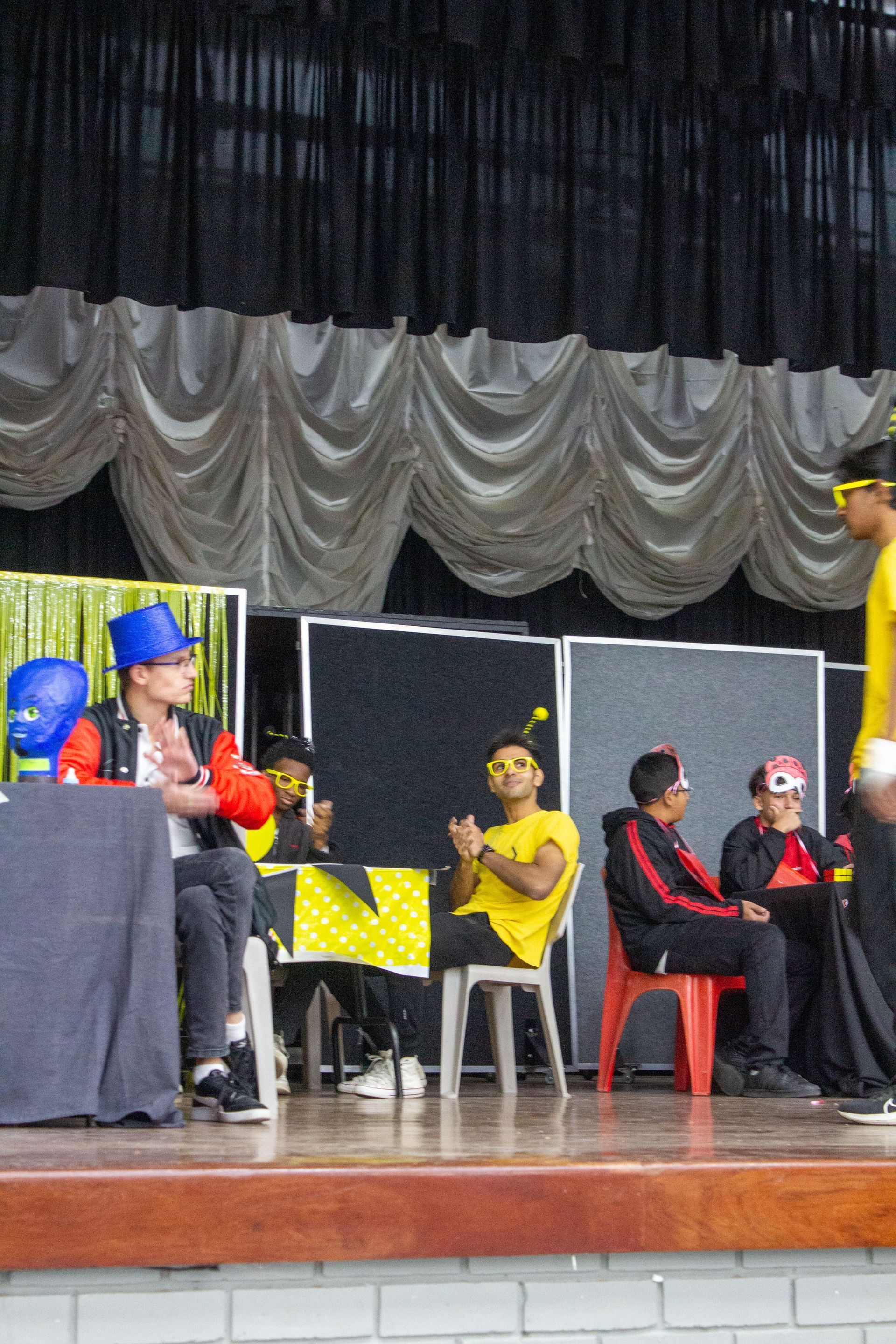 A group of people are sitting in chairs on a stage
