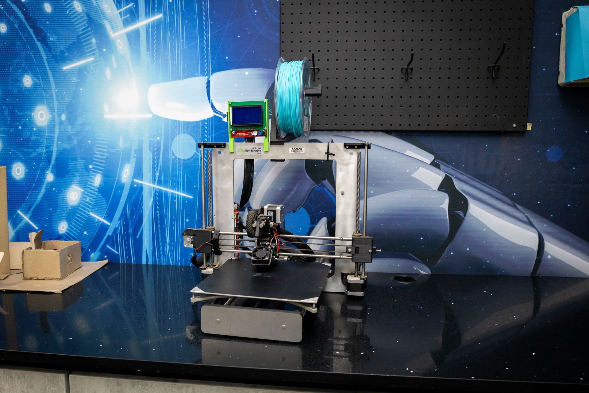 two girls are using computers in a room with the word technology on the wall