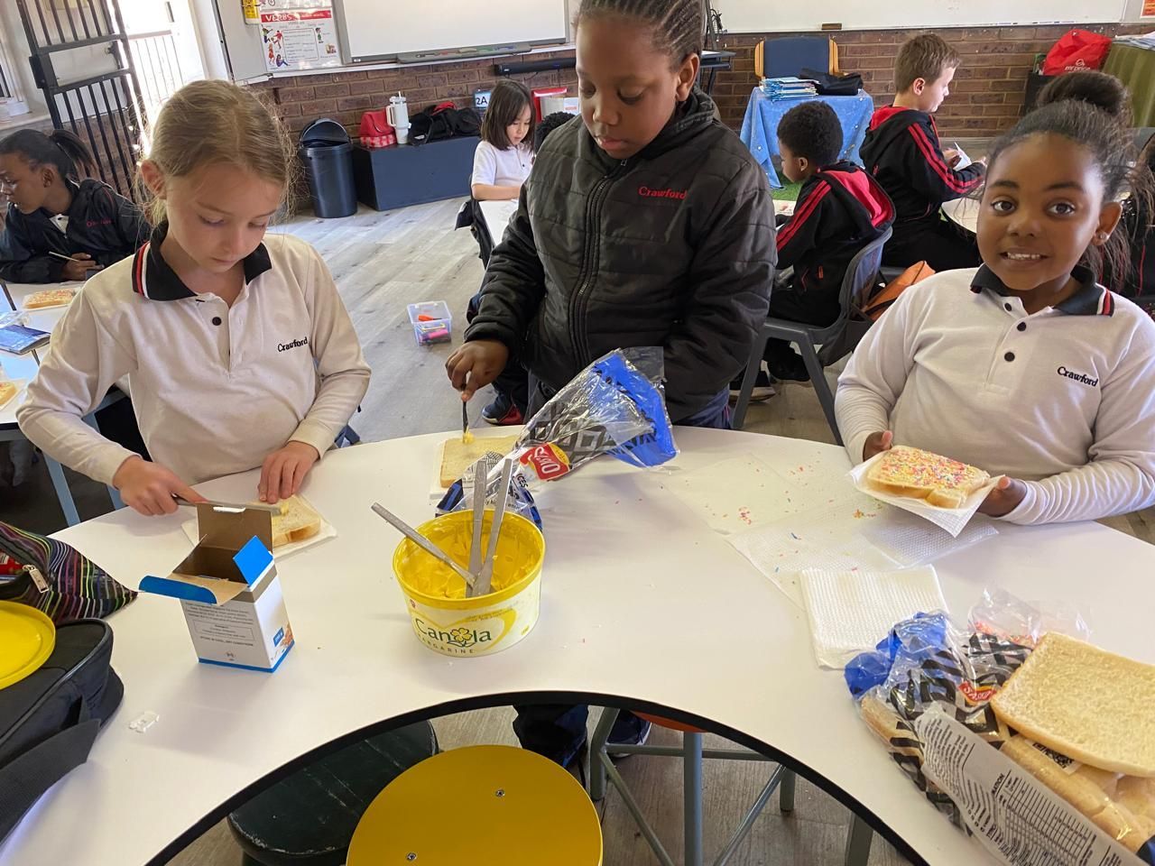 A group of children are sitting at a table eating food.