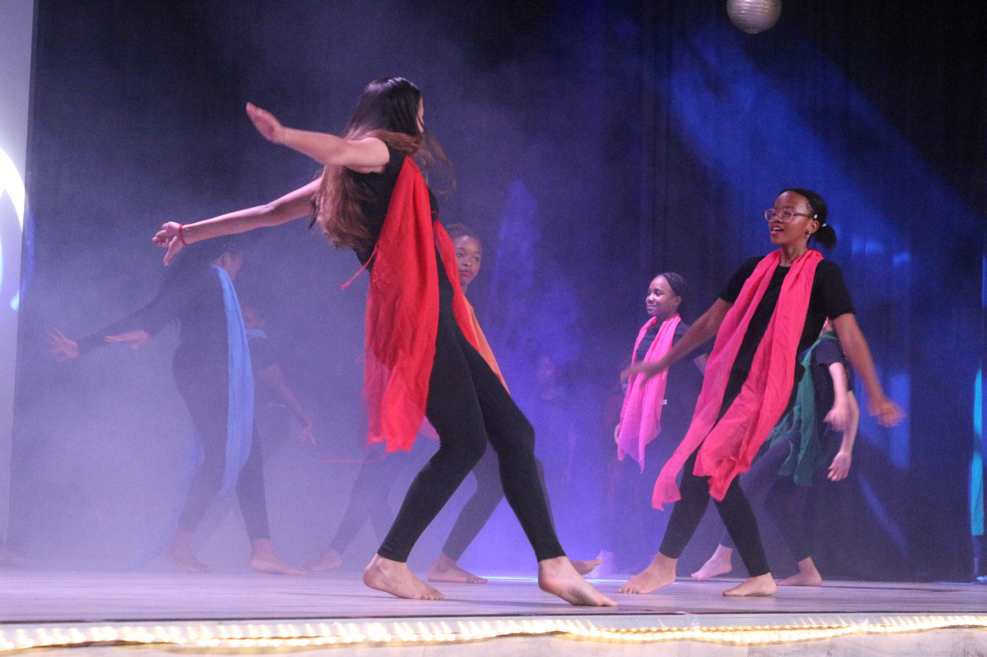 a group of young girls are posing for a picture on a stage .