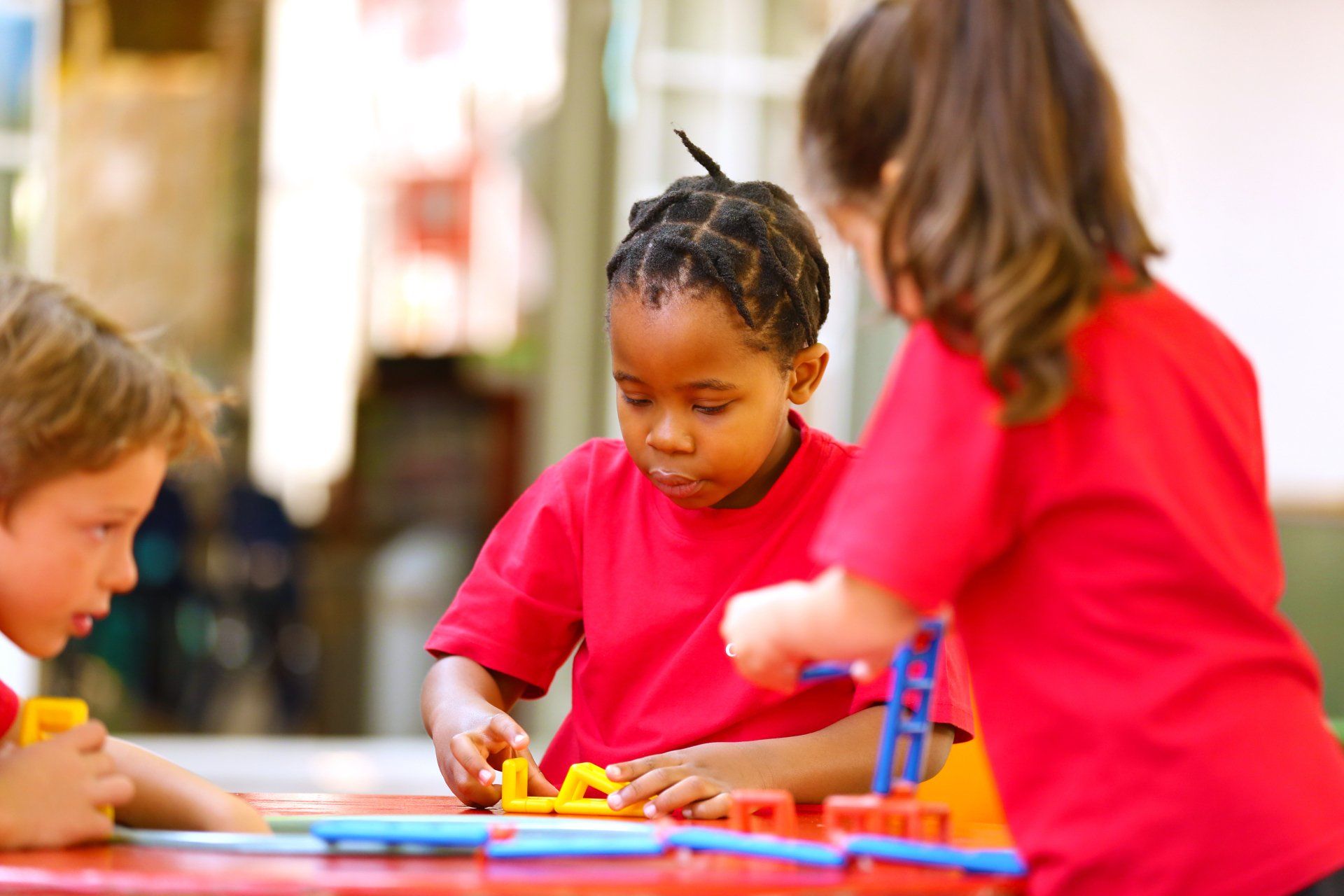a group of children are playing with toys at a table .