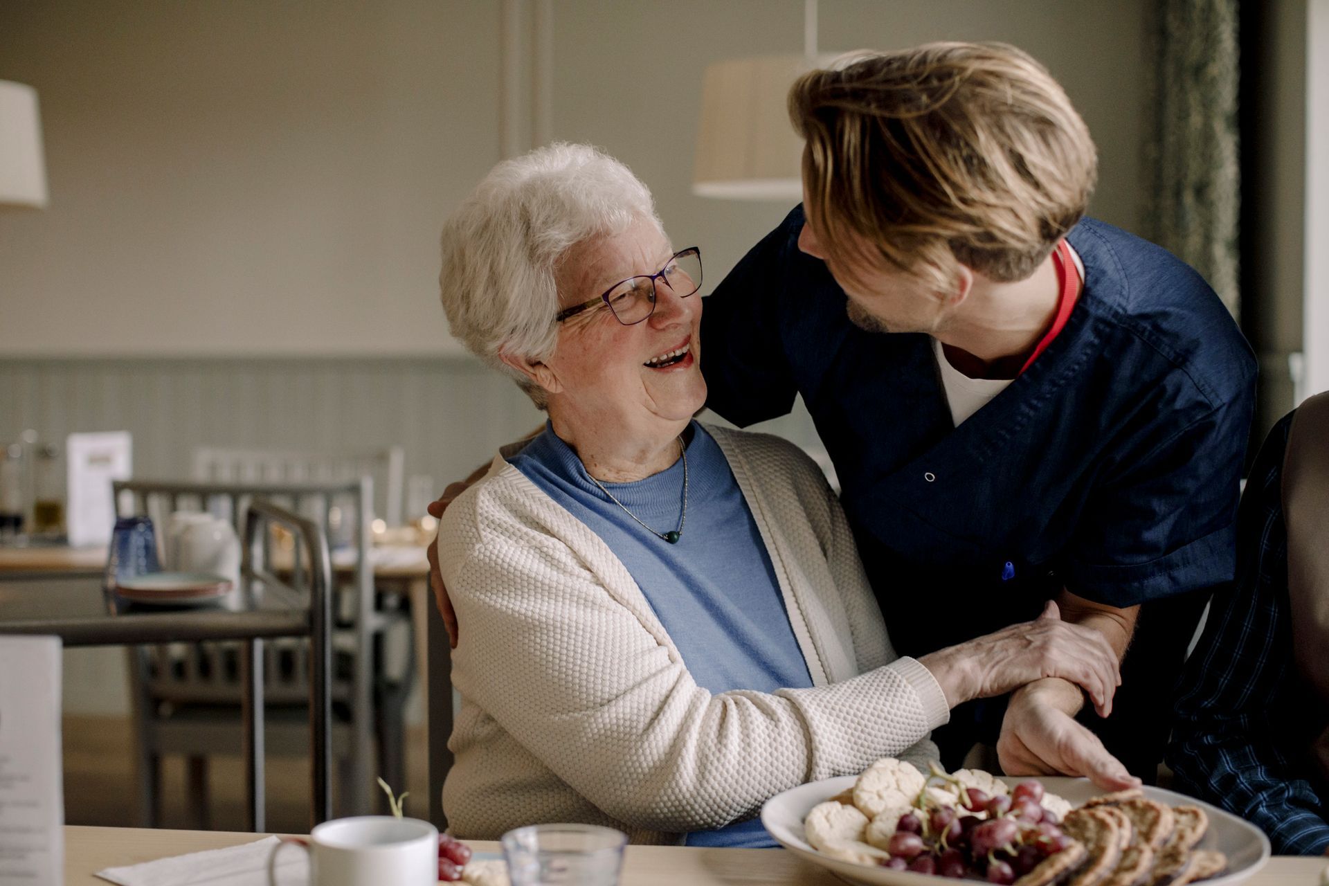 Persona che stira una camicia bianca con un ferro da stiro industriale su un asse da stiro blu.