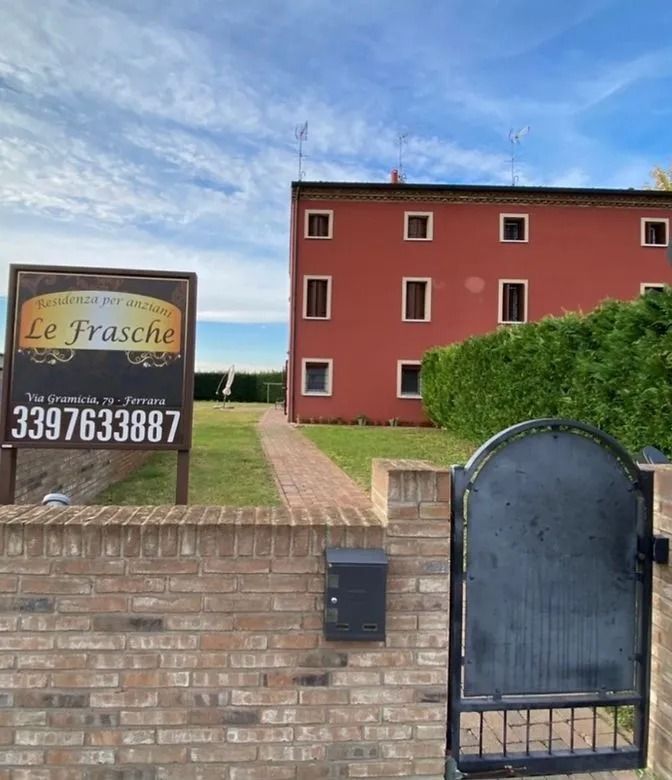 Un edificio rosso con un'insegna per 